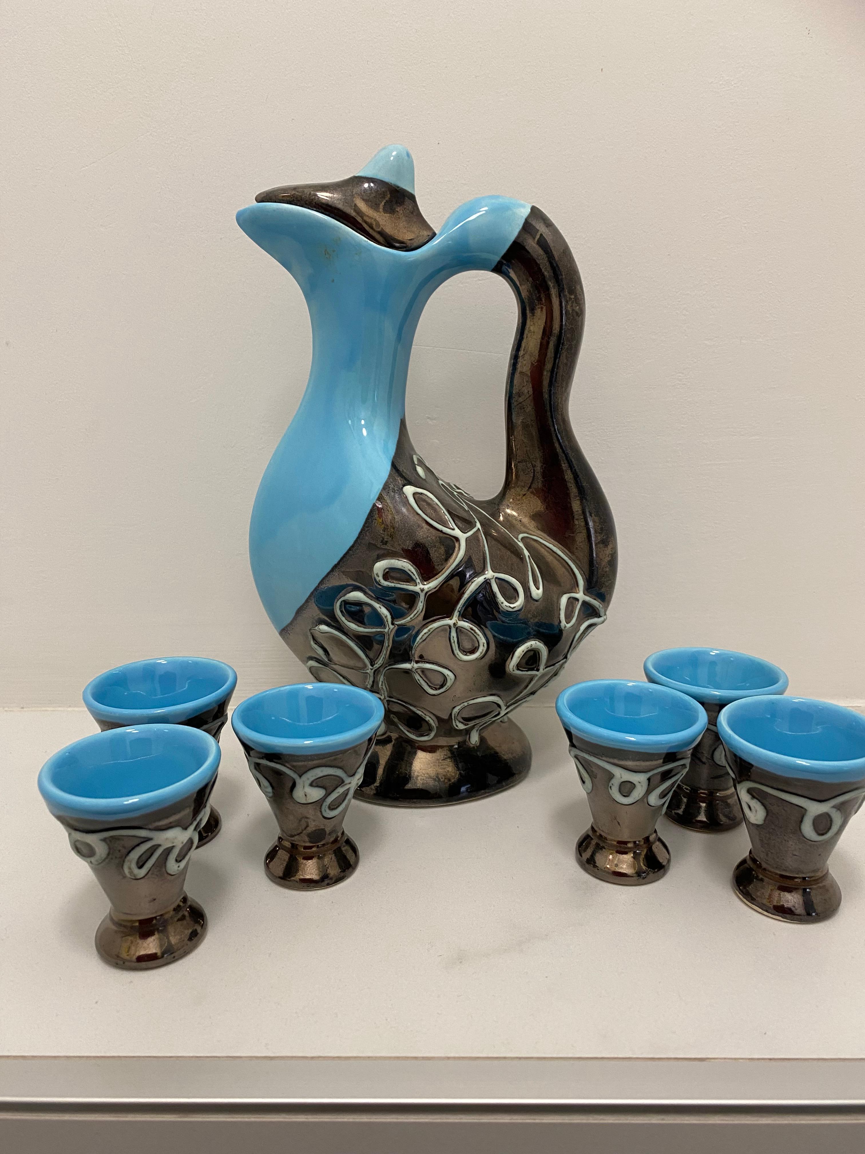 Un set di liquori molto bello proveniente da Vallauris, nel sud della Francia. 
Il set comprende una caraffa con tappo. La maggior parte delle brocche non ha il tappo. Altre 6 tazze di 6 cm di altezza e 4,5 cm di diametro.
Il colore è un vibrante