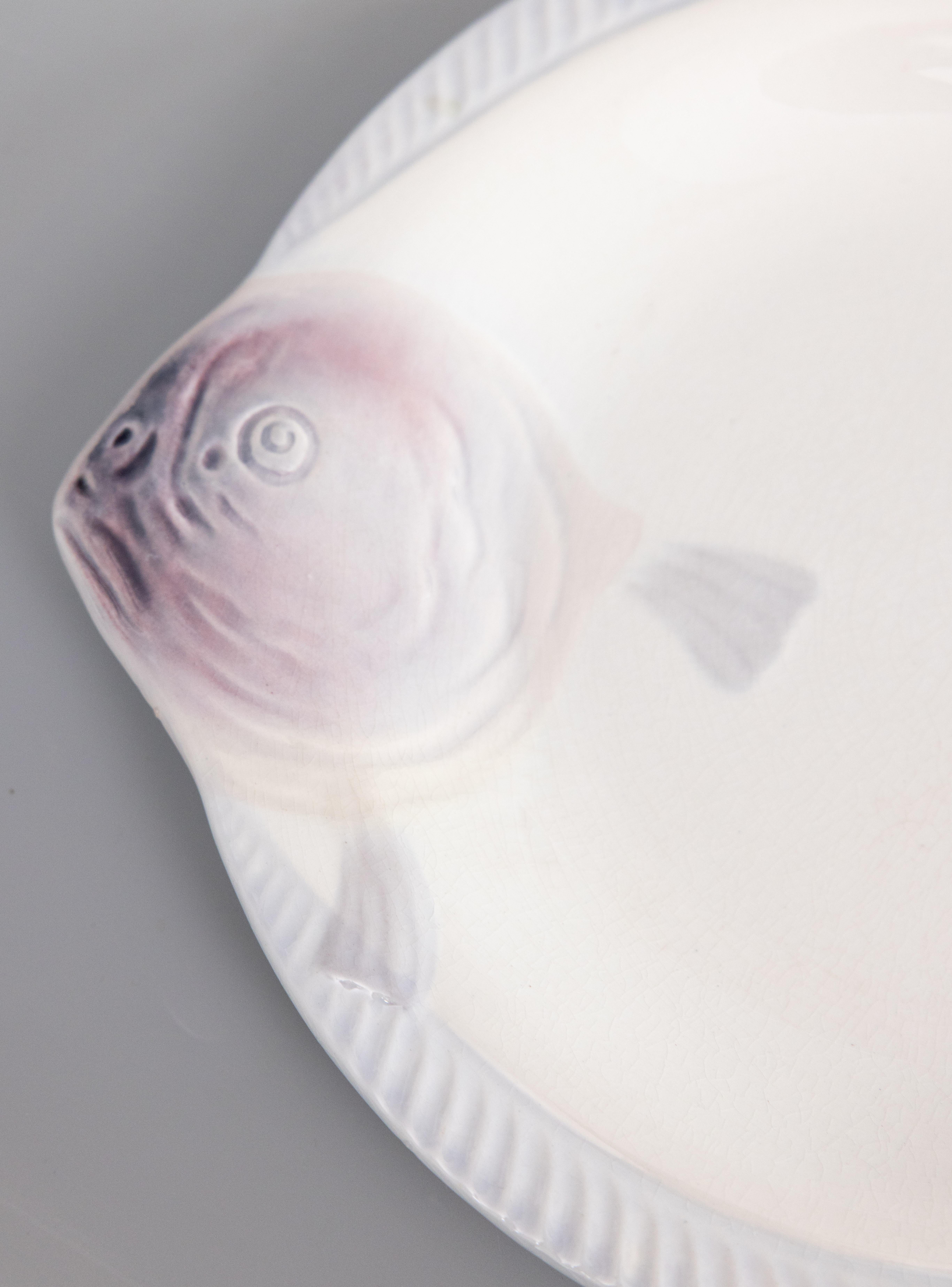 Une élégante assiette à poisson Art déco en majolique française CIRCA, vers 1930. Marque du fabricant au revers. Il s'agit d'une couleur rare, le blanc avec de jolis accents lilas violet doux, et il s'affiche magnifiquement, parfait pour votre décor
