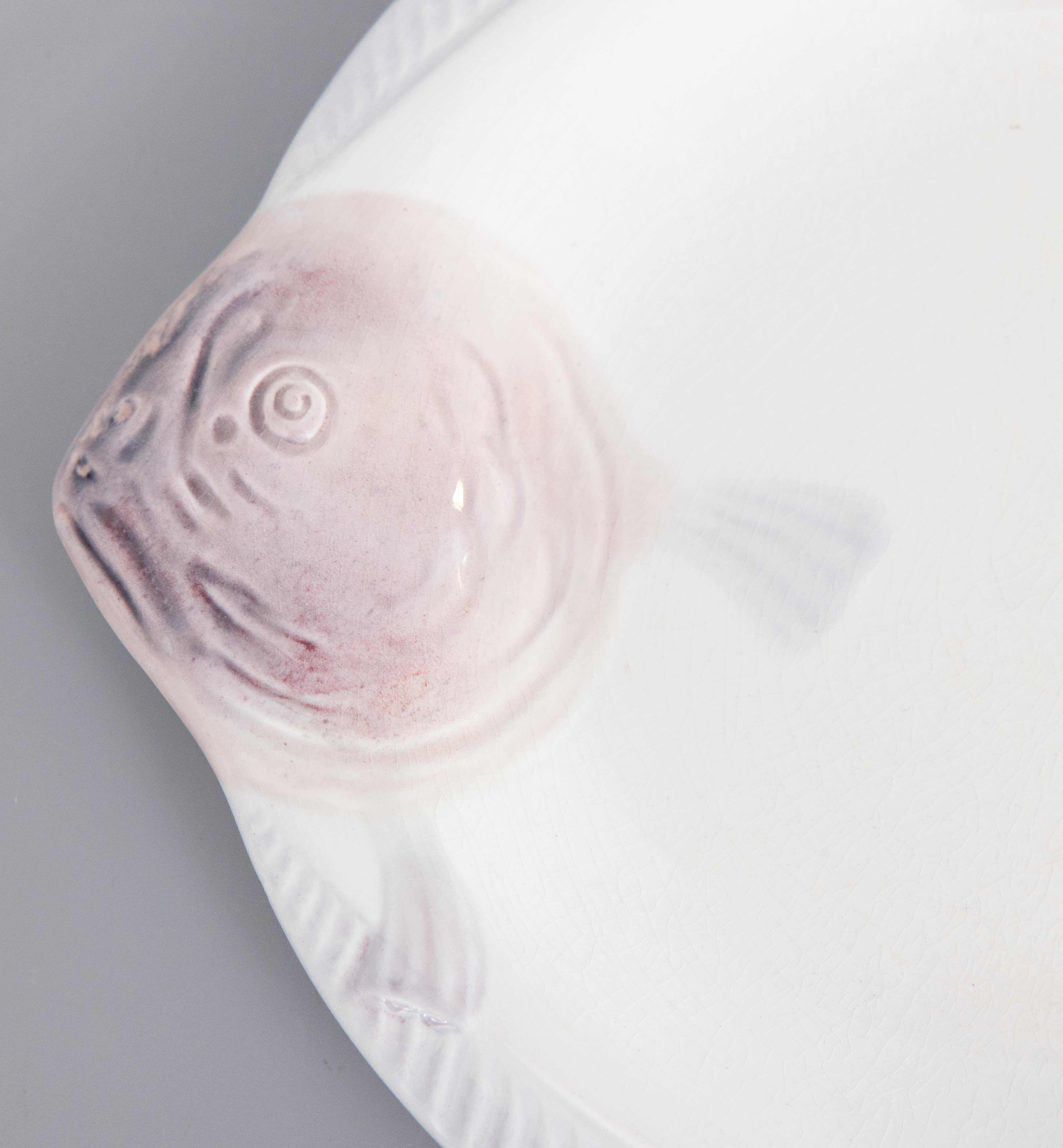 Une élégante assiette à poisson Art déco en majolique française CIRCA, vers 1930. Marque du fabricant au revers. Il s'agit d'une couleur rare, le blanc avec de jolis accents lilas violet doux, et il s'affiche magnifiquement, parfait pour votre décor