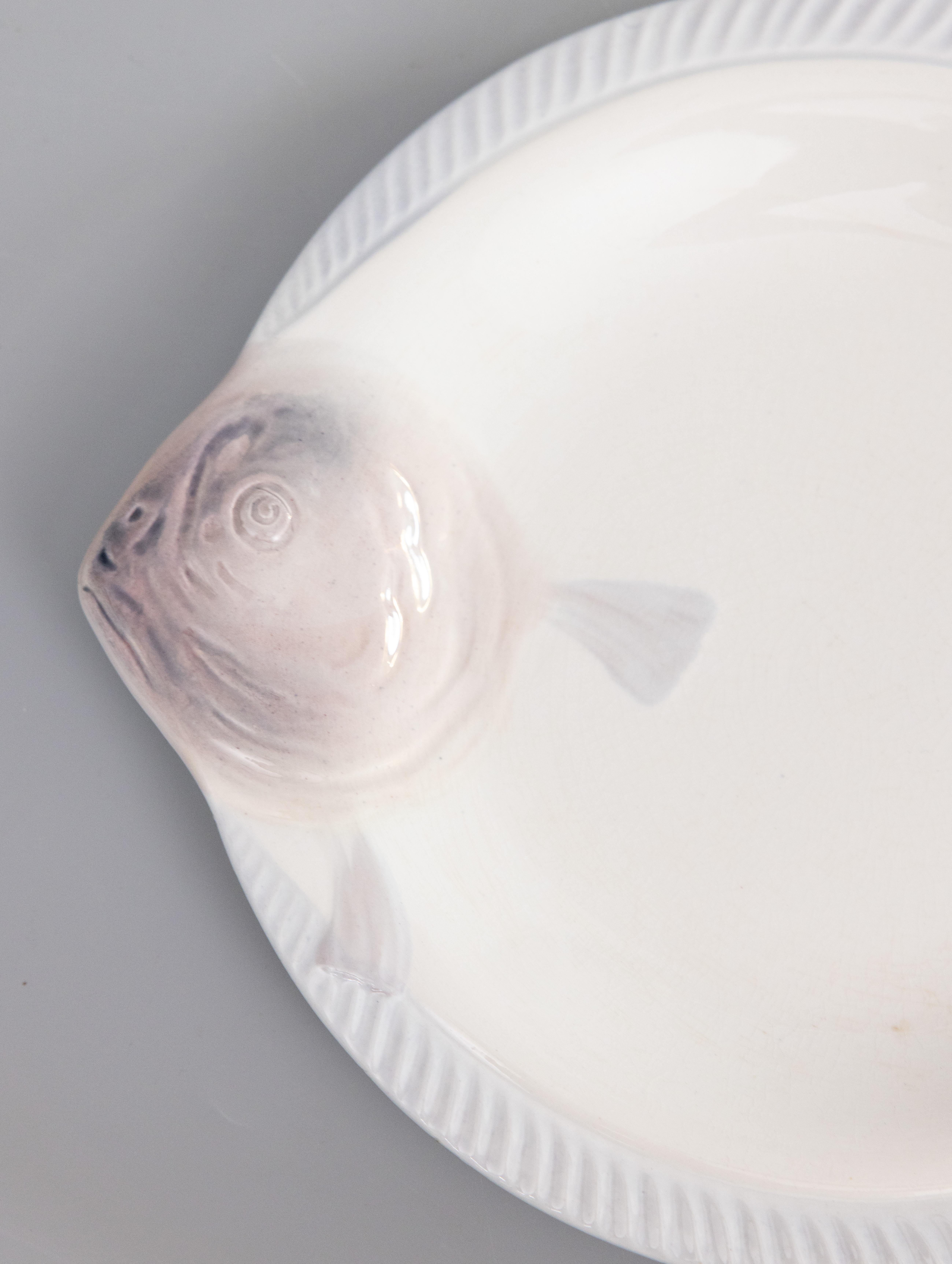 Une élégante assiette à poisson Art déco en majolique française CIRCA, vers 1930. Marque du fabricant au revers. Il s'agit d'une couleur rare, le blanc avec de jolis accents lilas violet doux, et il s'affiche magnifiquement, parfait pour votre décor
