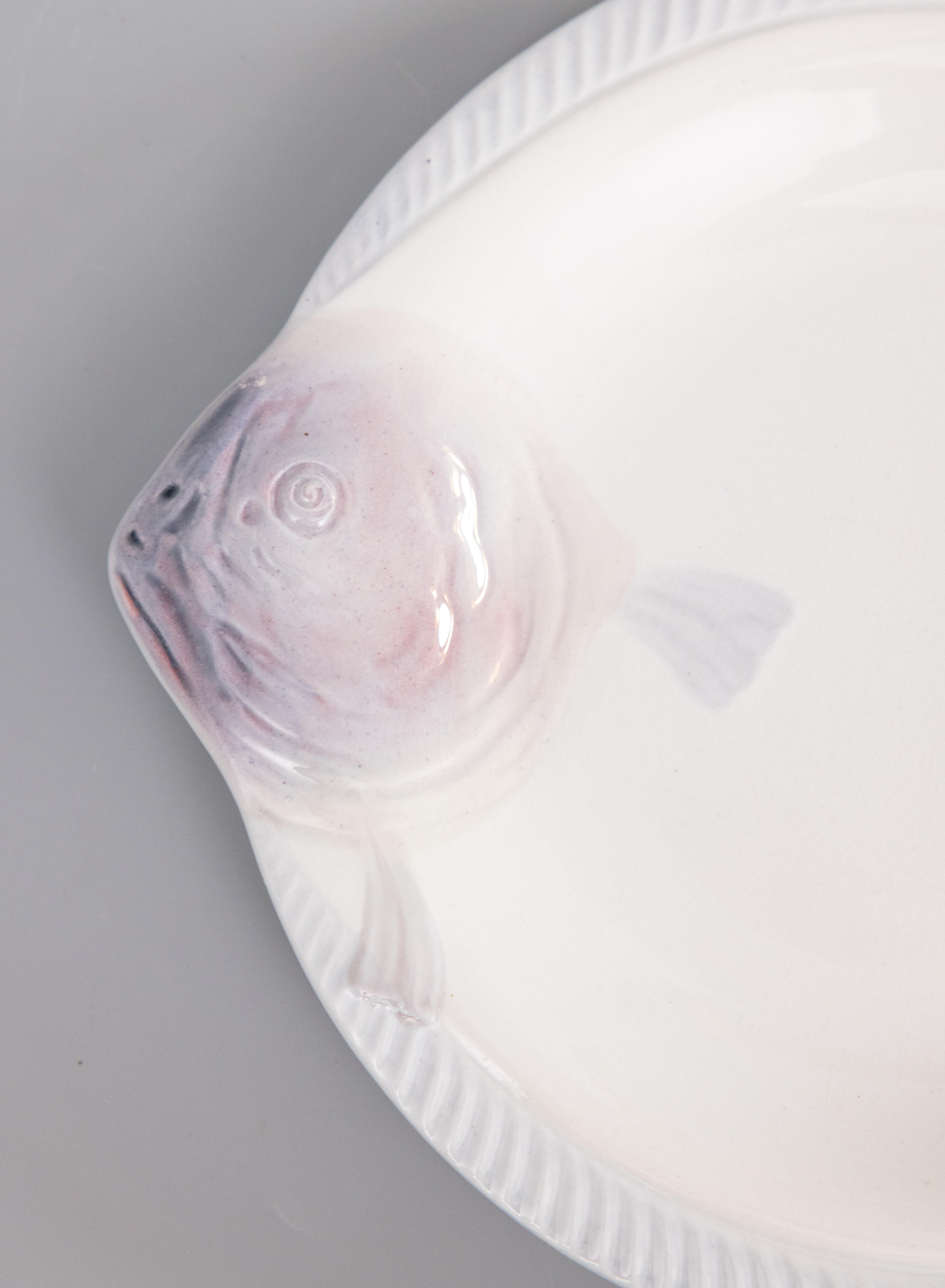 Une élégante assiette à poisson Art déco en majolique française CIRCA, vers 1930. Marque du fabricant au revers. Il s'agit d'une couleur rare, le blanc avec de jolis accents lilas violet doux, et il s'affiche magnifiquement, parfait pour votre décor