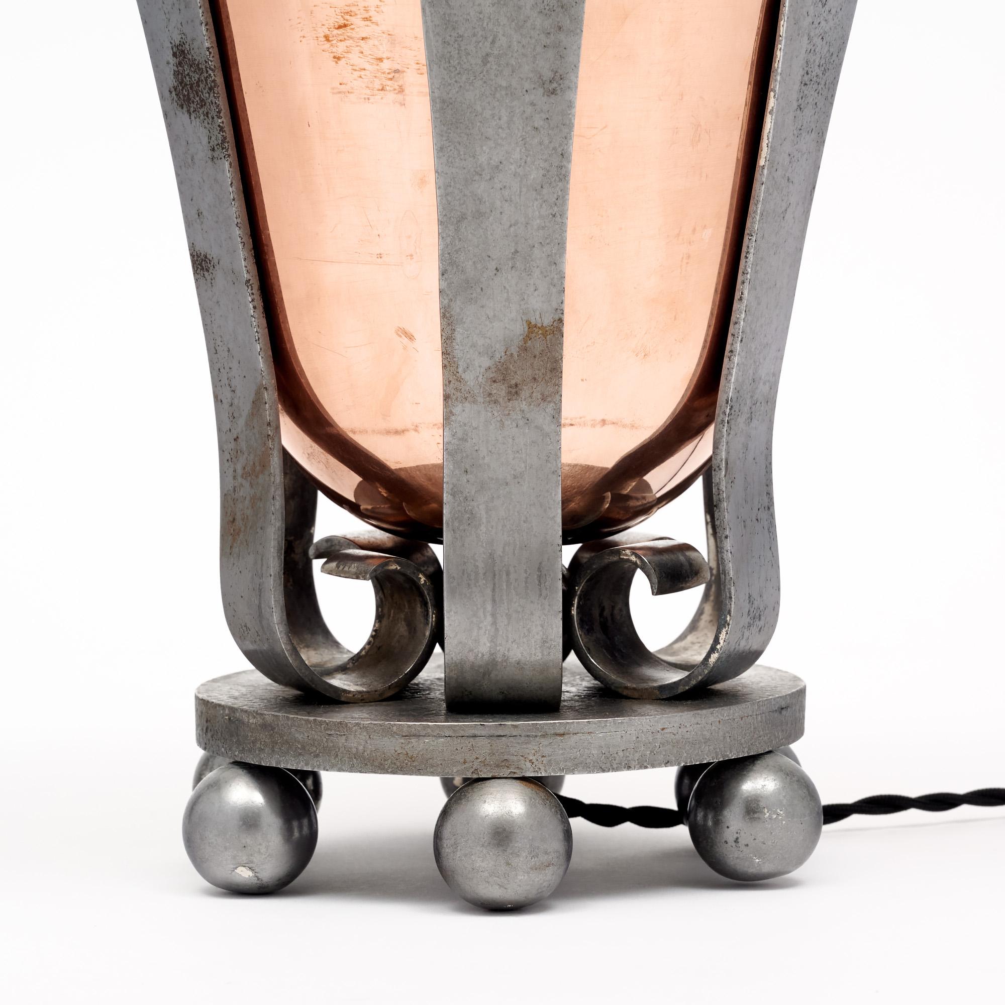 Lampe de la période Art Déco en France, en cuivre et en fer. La partie intérieure en forme d'urne est en cuivre, tandis que les détails décoratifs extérieurs sont en fer. Cette pièce a été nouvellement câblée pour correspondre aux normes
