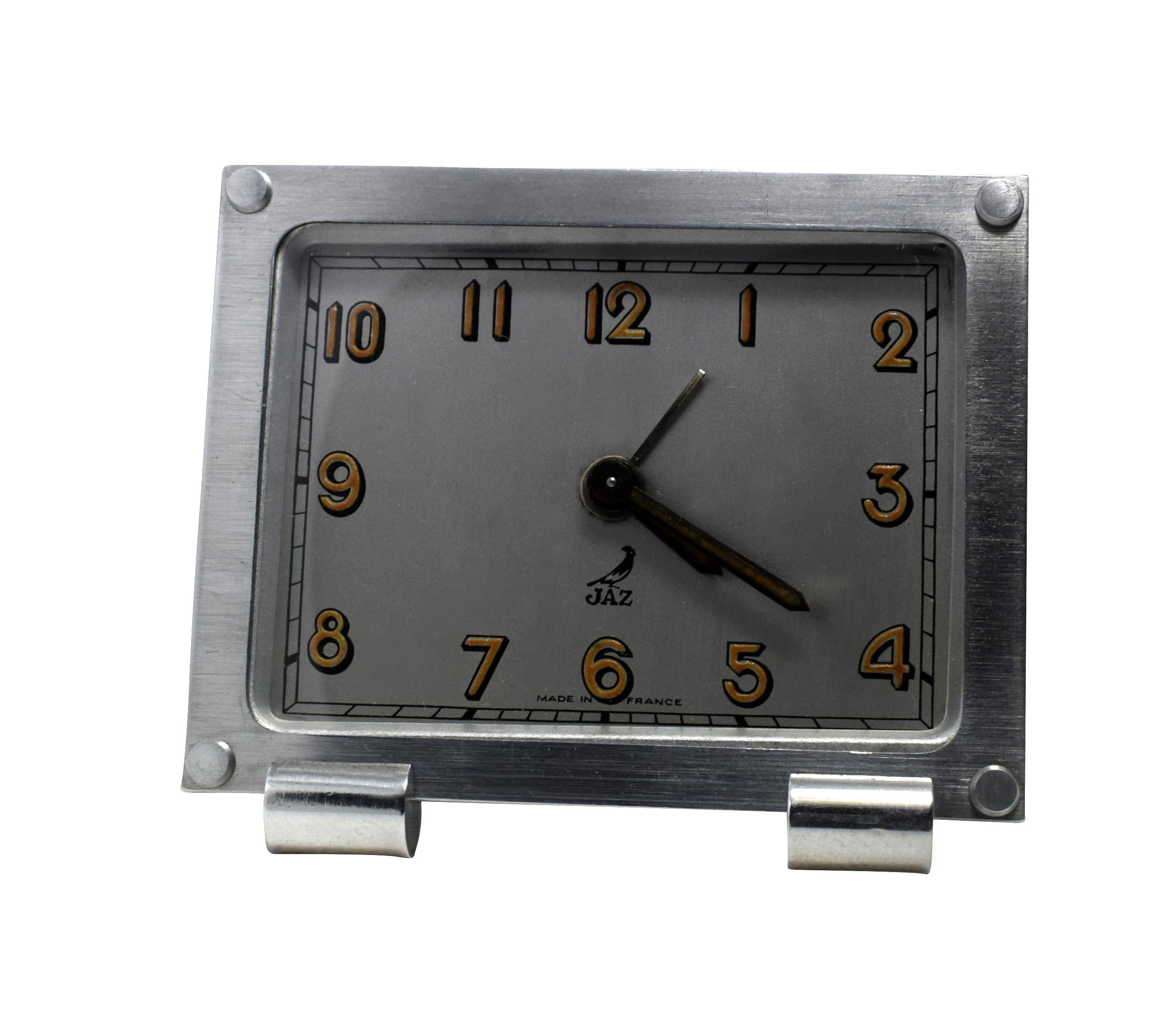 Very stylish 1930s chrome cased alarm clock by the French clock makers JAZ. This charming little clock has a silvered dial face with mustard yellow numerals making an attractive contrast and appealing look. Slender shaped and free standing with good