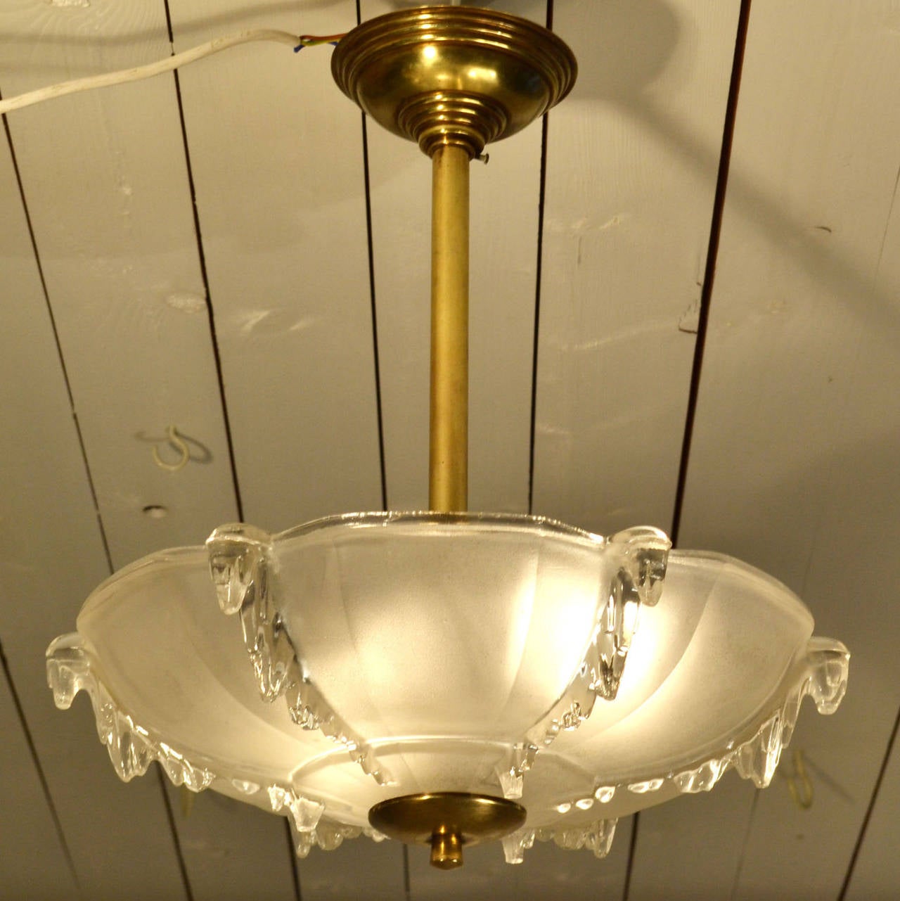 Typical French 1930's flush mount up-lighter. The molded glass shade is part frosted and decorated with clear ice pegs. The shade is connected to the ceiling by a brass stem.
