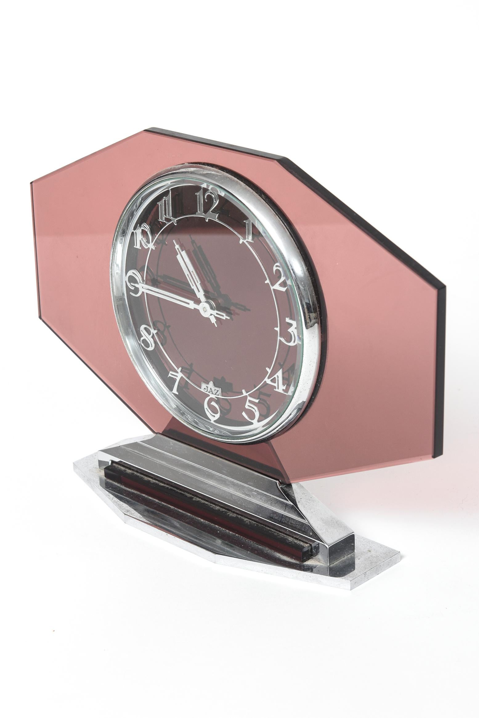 Art Deco French pink glass 'Jaz' 8-day clock. Pink glass with silver numerals and hands and metal base & top. Face has JAZ on it. Art Deco (c. 1910-1939). The clock is working.

Overall size is 7” high by 9 3/4” wide by 2”deep.