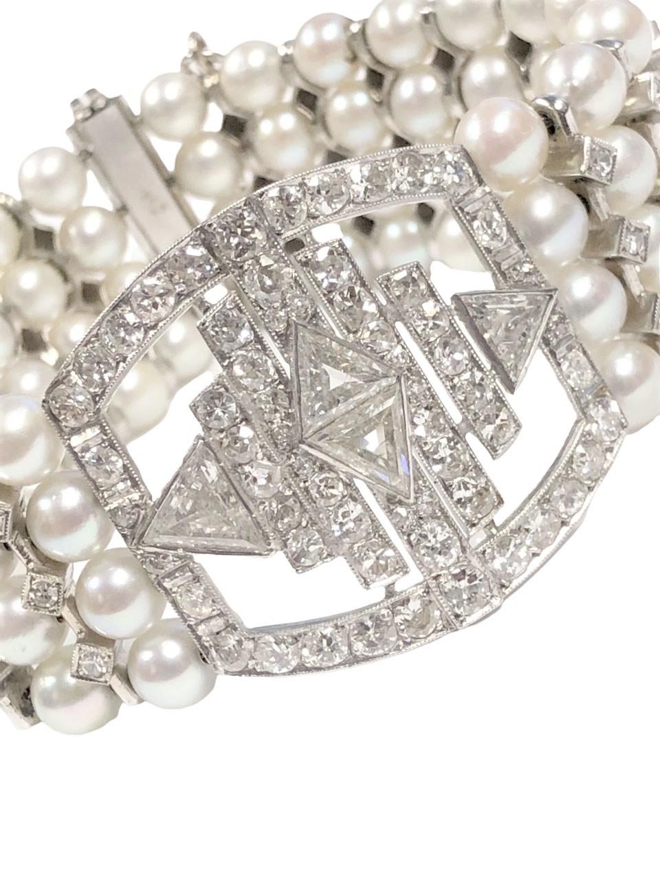Circa 1930s French Platinum Bracelet in a very Art Deco Style, measuring 7 1/2 inches in length and 1 3/16 inch wide. Comprised of 5.5 M.M. Round Cultured Pearls of fine Luster, the central slightly curved section measures 1 1/4 x 1 3/16 inch and is