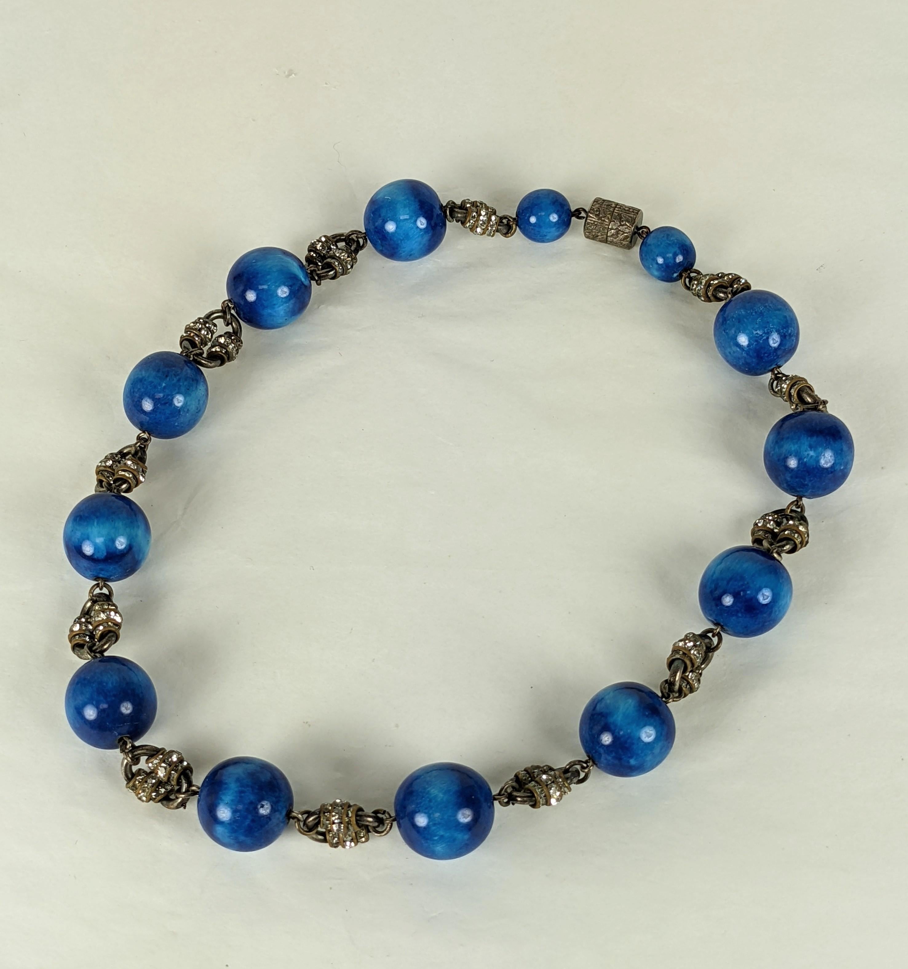 Elegante collana di ceramica e pasta francese Art Deco degli anni Venti. Le perle di ceramica fatte a mano di colore blu ombreggiato sono intervallate da maglie in silverplate decorate con rondelle in pavé. Chiusura a giro d'epoca.  Francia anni