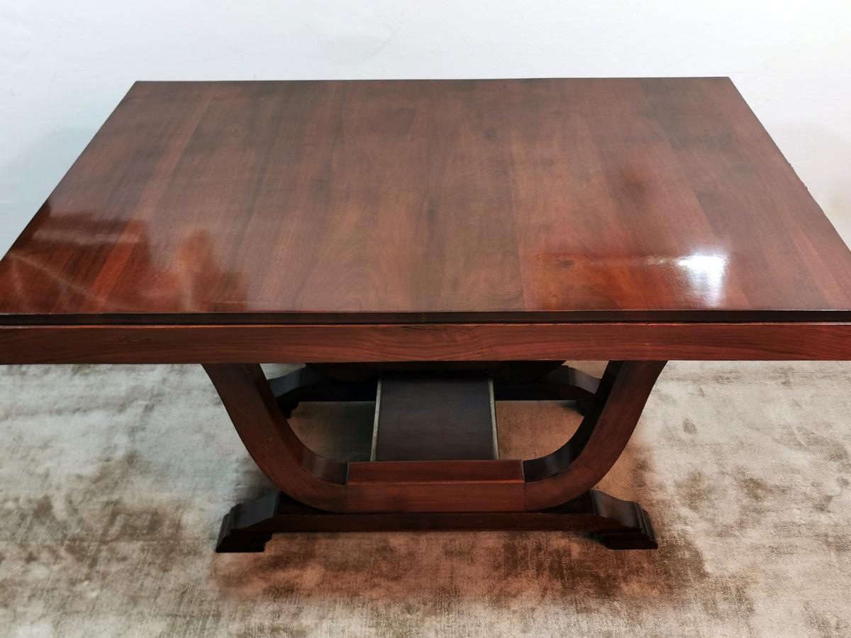 Fascinating and refined extendable dining table; the rectangular top is made of a precious exotic wood very hard and heavy with beautiful and delicate veins; the massive edge underneath, on both shorter sides, has been carved and carved by hand with