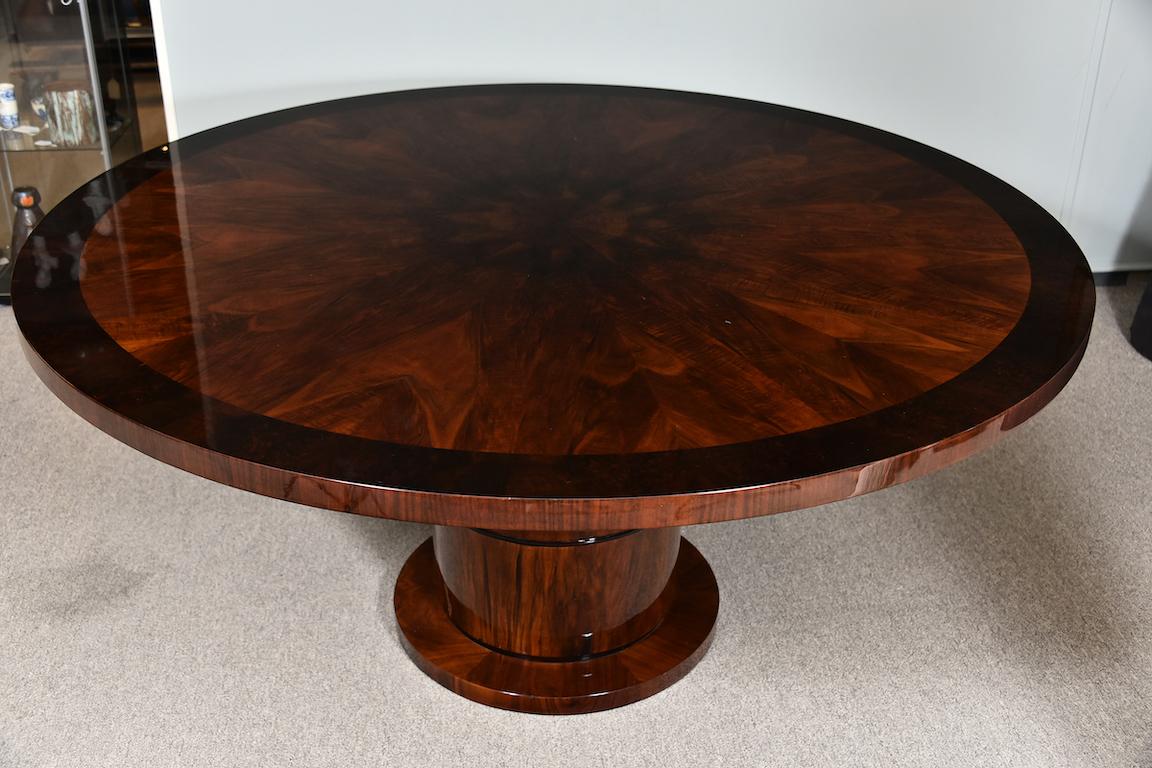Dining room table is done with a high quality walnut wood. Table top has ebonized ribbon of wood on the edge. Base is a circular form and a wide leg is elevating tabletop. 

Condition is perfect. Restored

France, circa 1930s.

 Measures: 65”