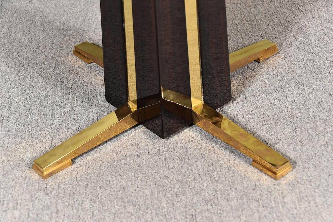 Beautiful Art Deco tabletop is displaying Macassar wood. Bottom of the tabletop is embellished with a brass ribbon. Base of the table is created by 2 intercepted brass pieces. Tabletop and the base are connected with each other by single leg.

