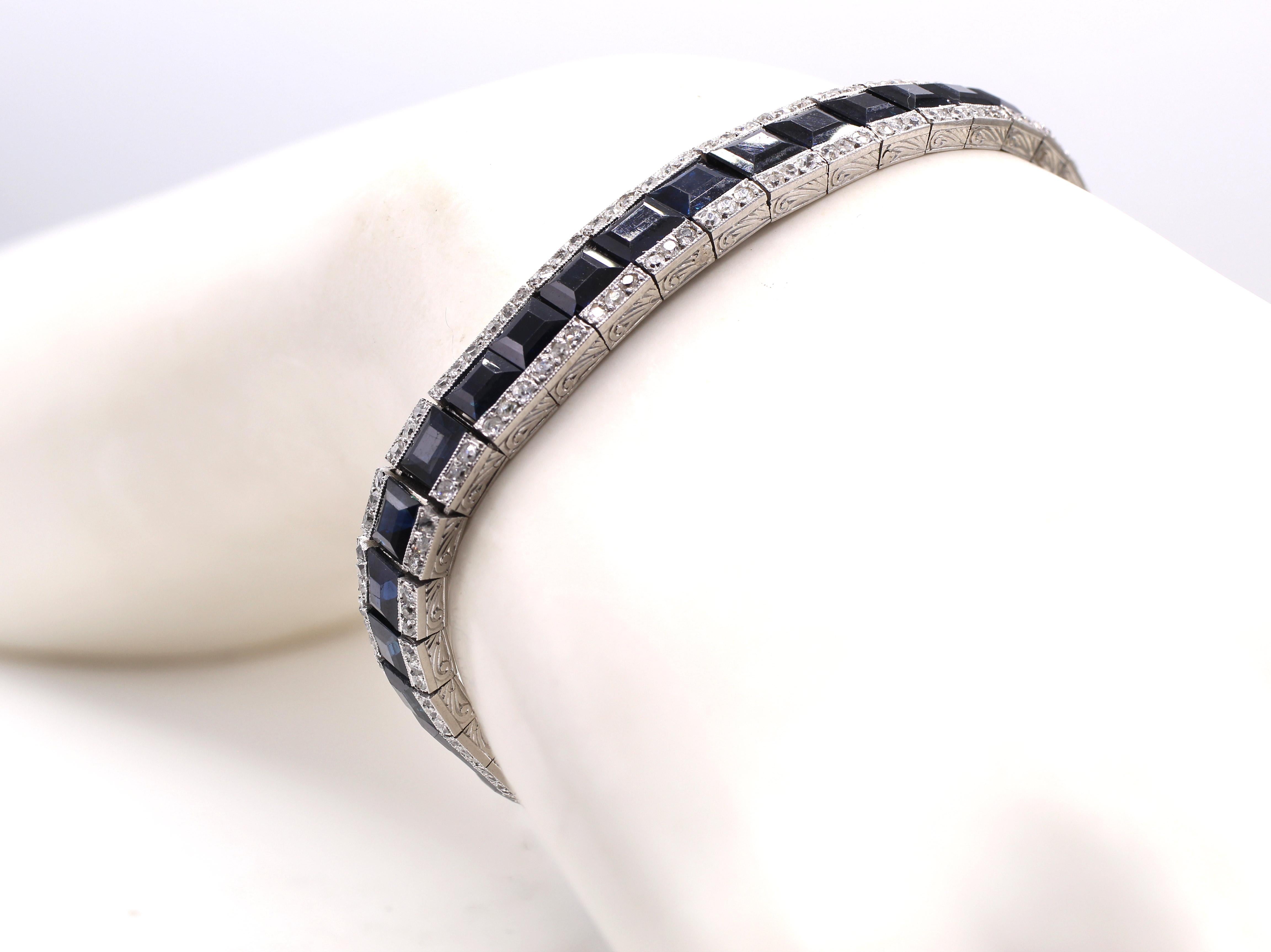Fine Art Deco bracelet from ca 1925 made in France. Set in platinum with a center channel of 41 dark blue well saturated step cut sapphires and embellished with small bright white old cut round diamonds on either side. The sides of this gorgeous