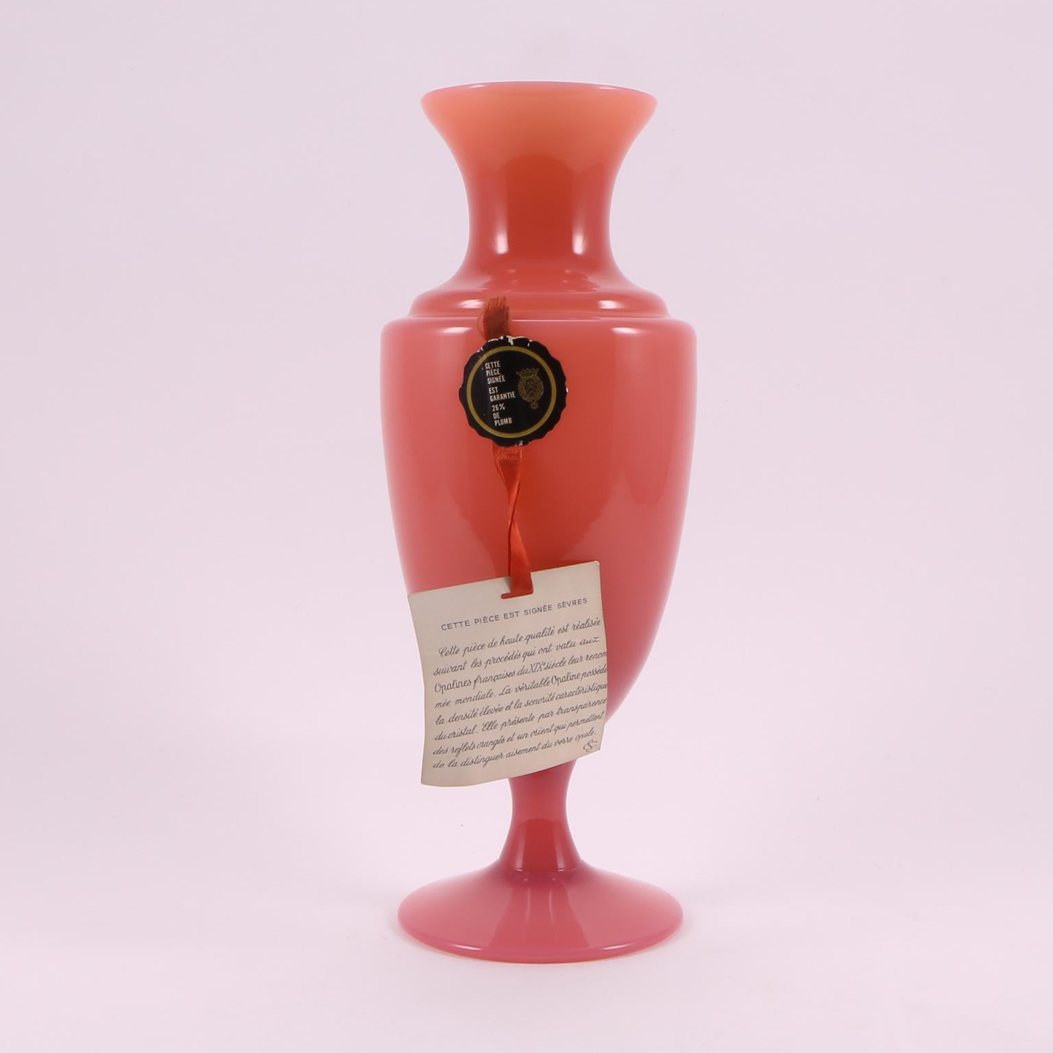 A charming Sèvres Cranberry pink opaline vase, hand blown in France, with a slender and elegant body.
Hand blown in France, with original ribbon and label, that are in perfect shape, and on the backward of the card you will find a description of