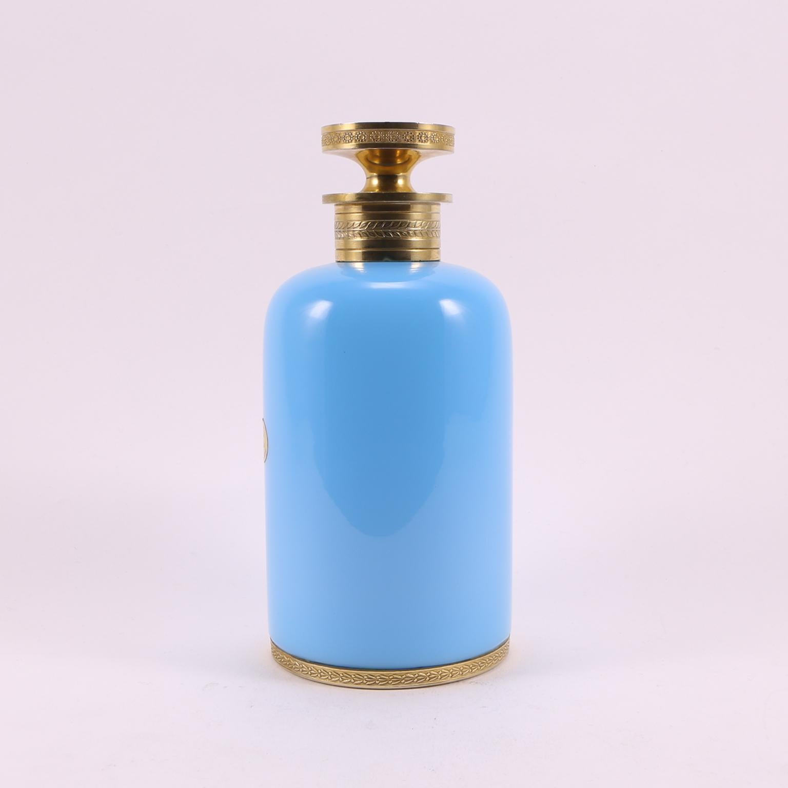 Voici un beau et ancien flacon de parfum en verre opalin de Sèvres de 1920, soufflé à la main en France, dans un charmant ton turquoise clair et des détails en métal doré.
Il a été réalisé par le célèbre designer et producteur L. Seiler.
Avec le