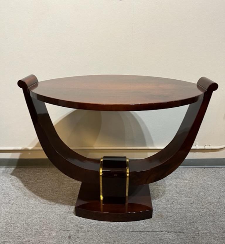 Oval shape of the table is displaying beauty of the walnut wood. It is elevated by the curved wooden band, that is attached to the rectangular base. Decorative element is the middle of the base is embellished with a chrome ribbon on each side.
