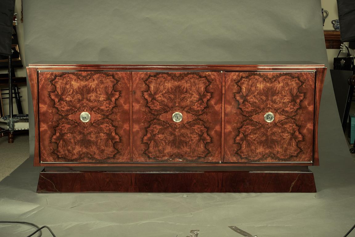 Sideboard made with burl walnut wood. It has three keyed drawers. Sides of the sideboard are slopped. It supported by the wide rectangular base. 
Condition is perfect.
Restored.

 France, circa 1930s
Measures: 79” W x 20” D x 36” H.
 