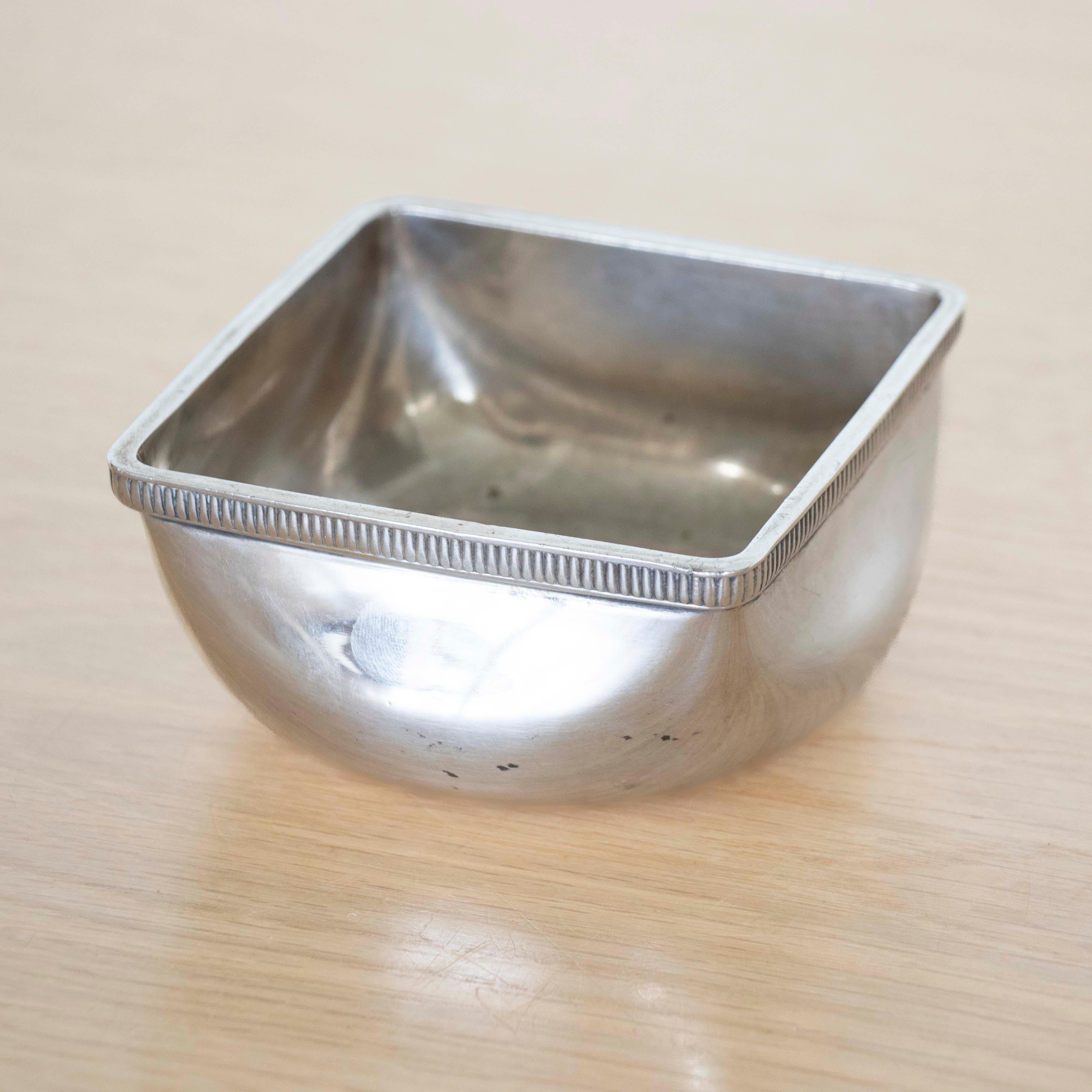 Beautiful late 19th c. silver plate bowl from France. Petite bowl with squared corners and rounded base. Lovely thin ribbed detail around edge. Original finish shows nice patina. Perfect as a decorative object or catchall. Stamped Ercuis on