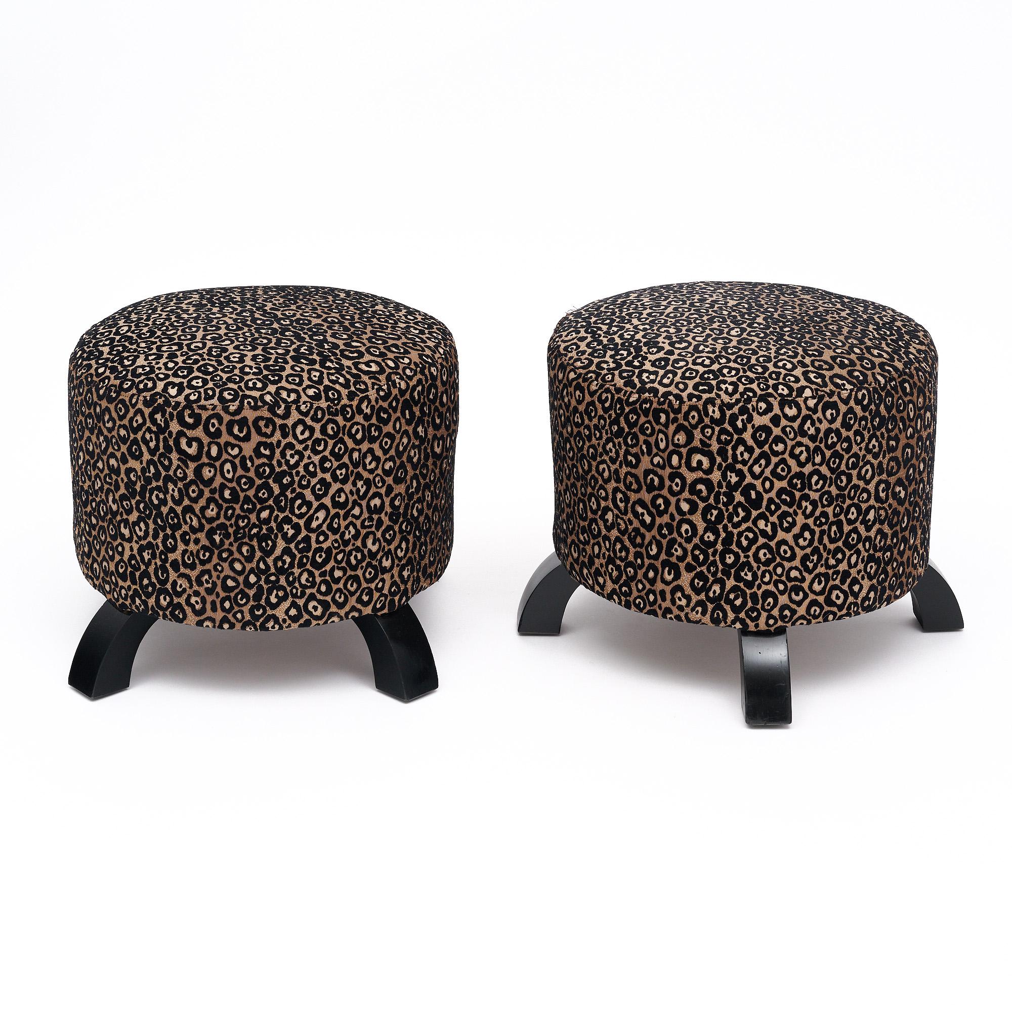 Pareja de taburetes de época Art Déco Francia. Cada taburete tiene un asiento cilíndrico tapizado con la tapicería original de estampado de leopardo negro y dorado. Los taburetes tienen cada uno cuatro patas ebonizadas con un lustroso acabado pulido