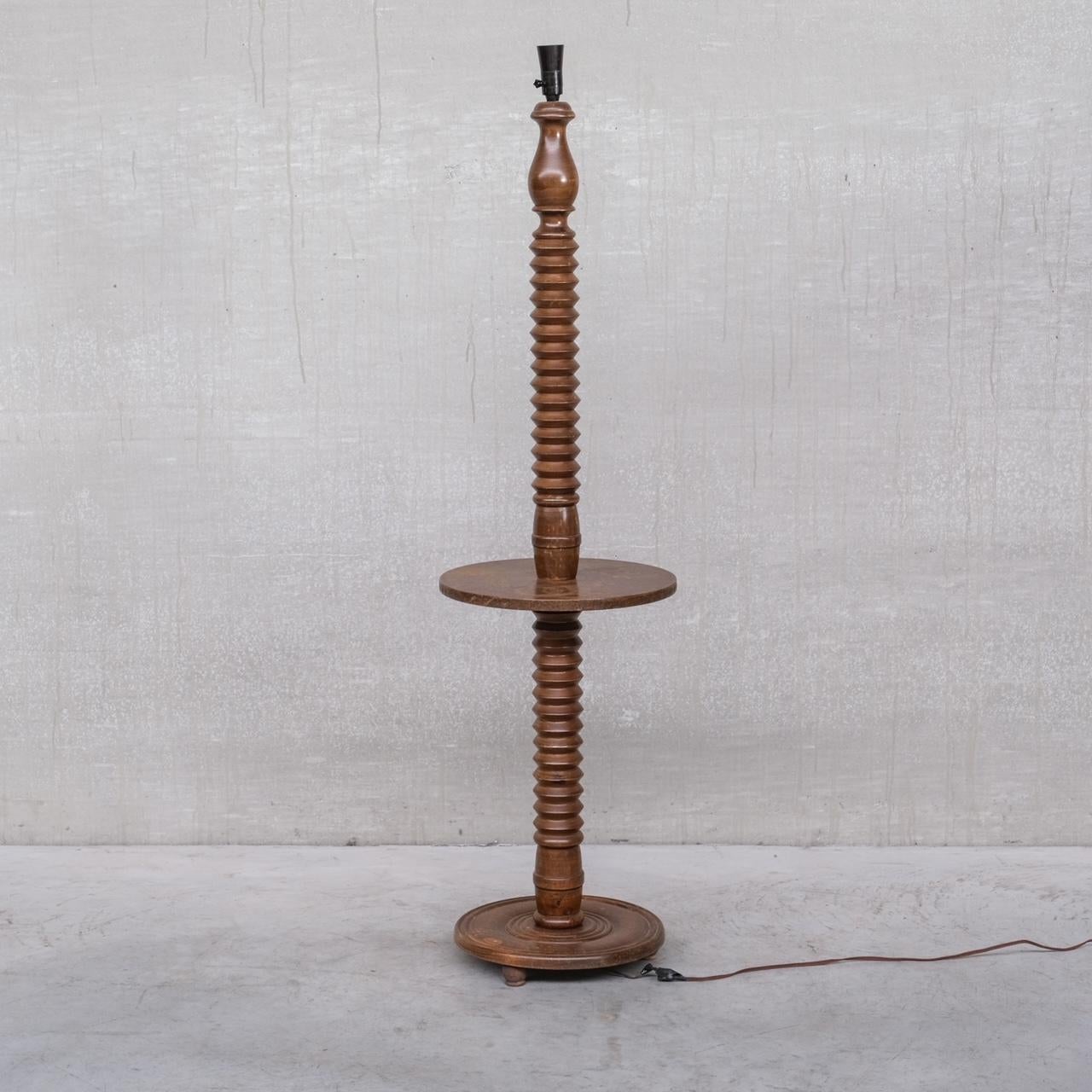 A turned wooden floor lamp. 

France, c1940s. 

In the manner of Charles Dudouyt. 

Since re-wired and PAT tested. 

Good vintage condition, some historical water marks which we have since had restored and worked out. Some scuffs and wear