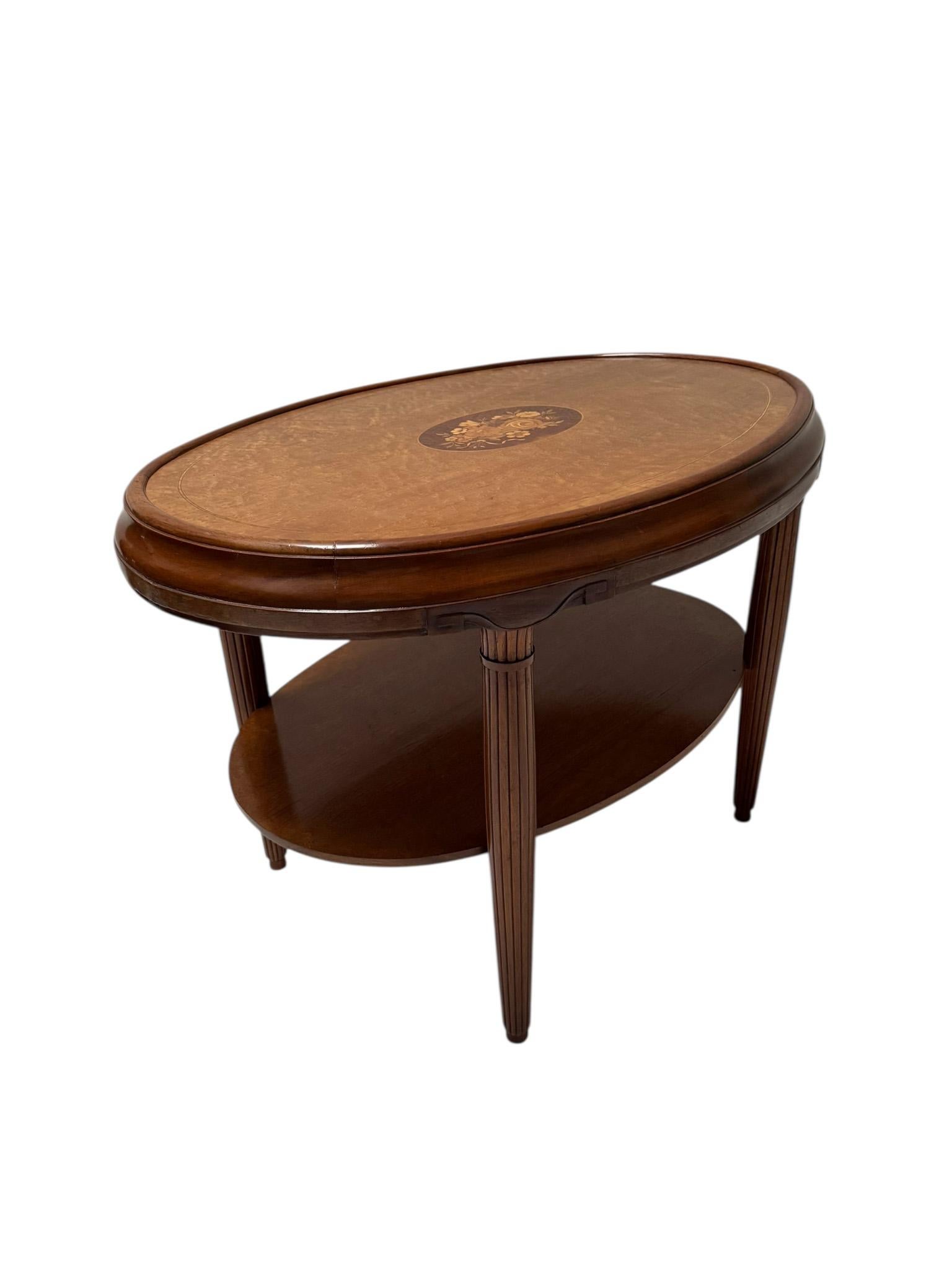Stunning and elegant Art Deco center table.
Striking French design from the 1930s.
Solid walnut frame with original Birdseye maple inlaid top.
There is a lower shelf for support and functionality.
This wonderful French Art Deco center table is in