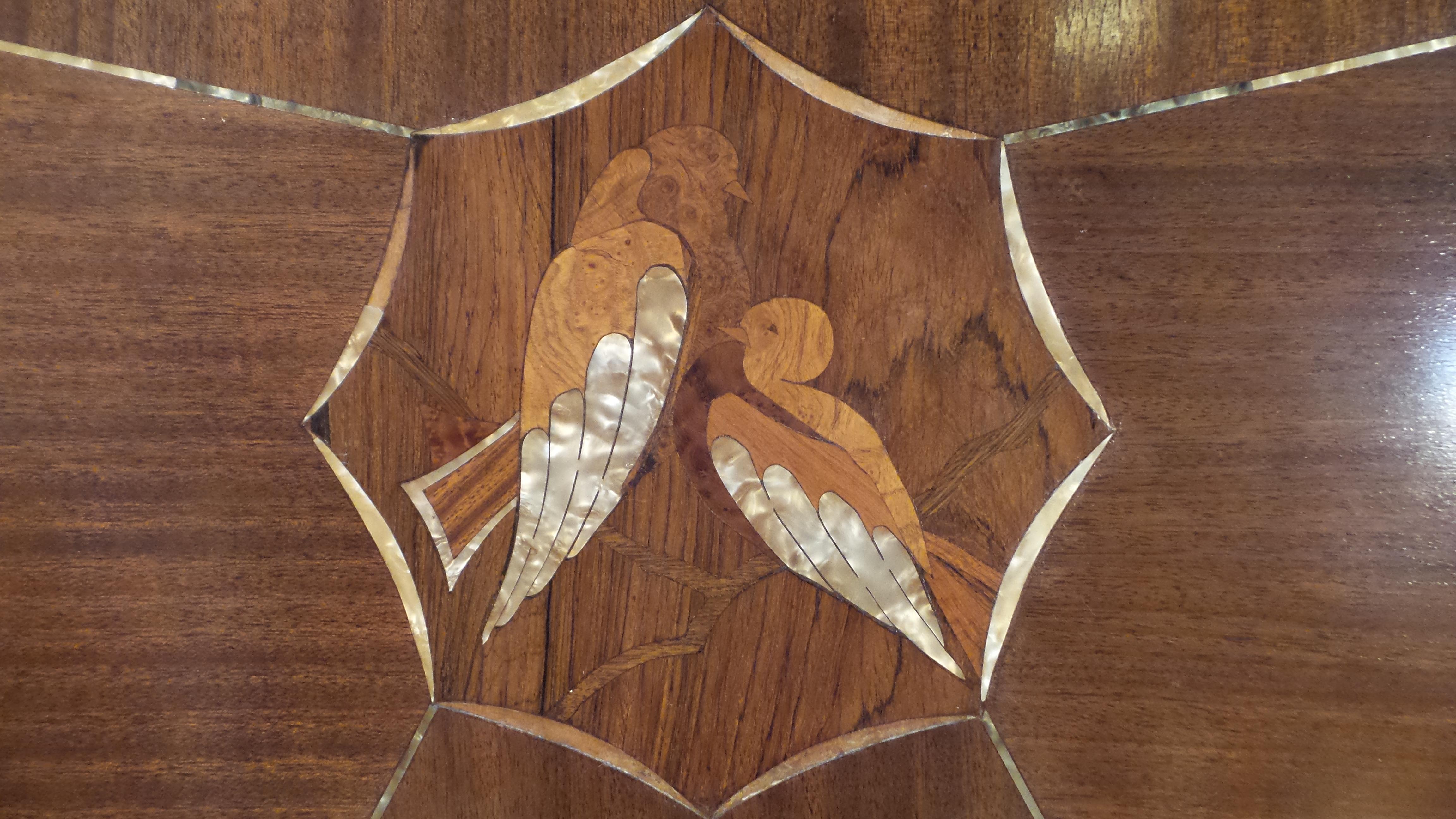An incredibly stunning original Art Deco double bed in walnut, boxwood and mother of pearl. The shape is iconic of the era.
The theme is of lovebirds and the beautifully detailed birds inlaid into this furniture has wings of mother of pearl,