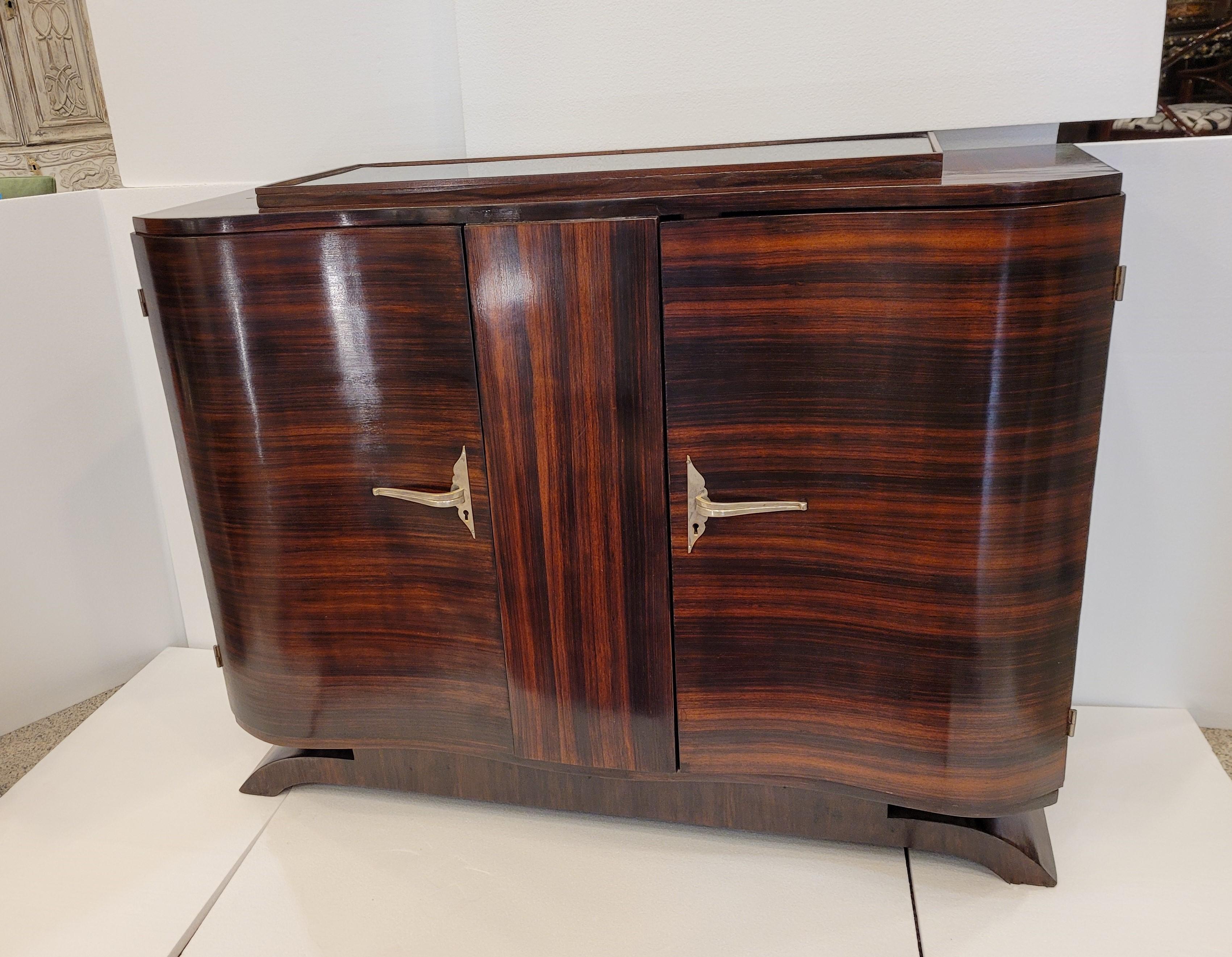 Amazing French chest of drawers made of precious wood, in an elegant veined reddish tone, original from the first half of the 40s of the 20th century. Characteristic design of Art Déco, with pure lines that tend towards geometrization, in this case