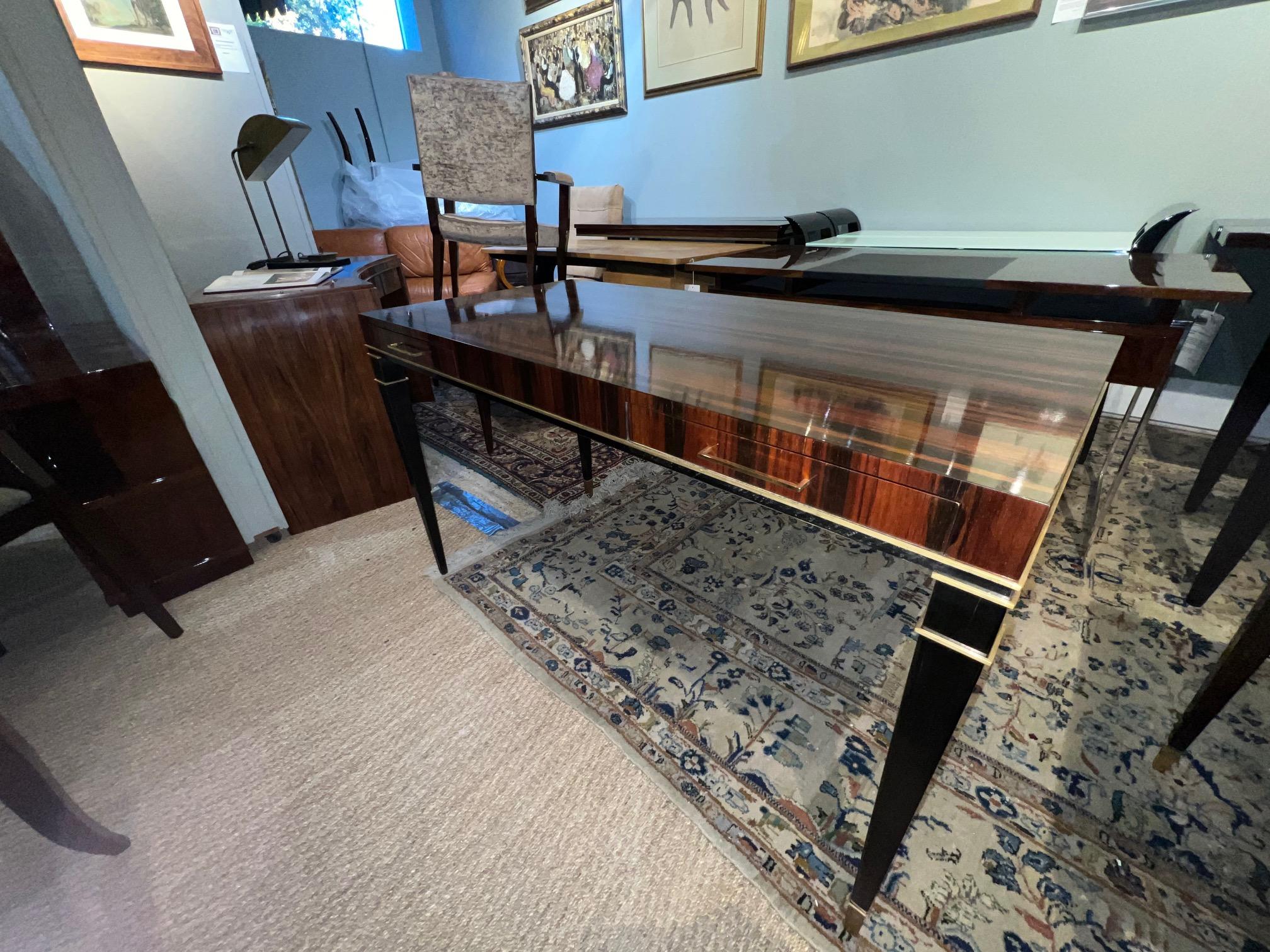 Beautiful and very elegant Art Deco French writing desk. It is made out of Macassar wood and legs are out ebonyzecd wood. Tips of legs are wrapped with brass holders. Desk has 2 spacious drawers ( 13