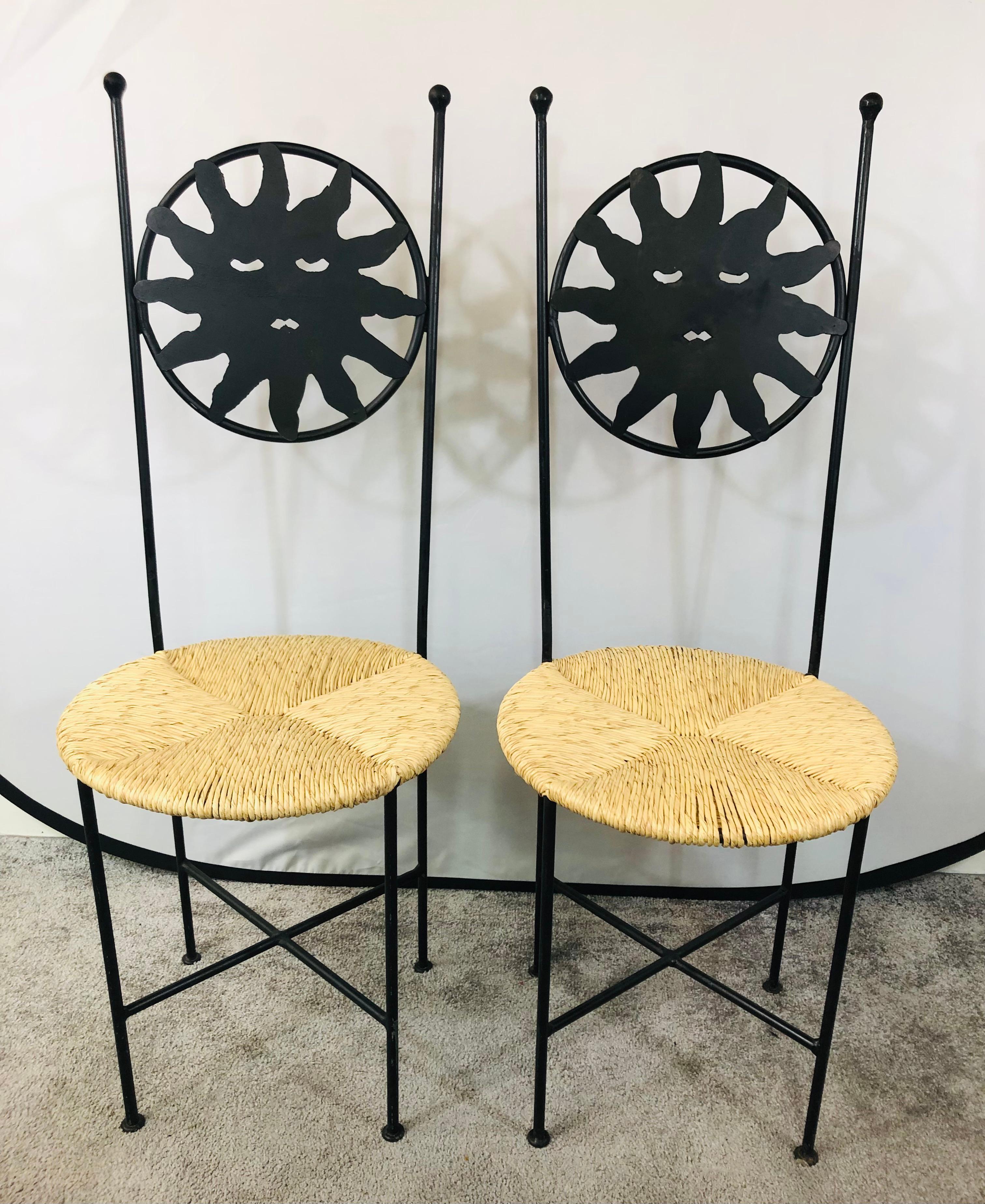 An exquisite set of four Art Deco wrought iron indoor or patio chairs. the circular shaped back of two chairs is carved to represent the sun and the other two the moon. Very slick and elegant, the chairs seat is made of Ratan which has been