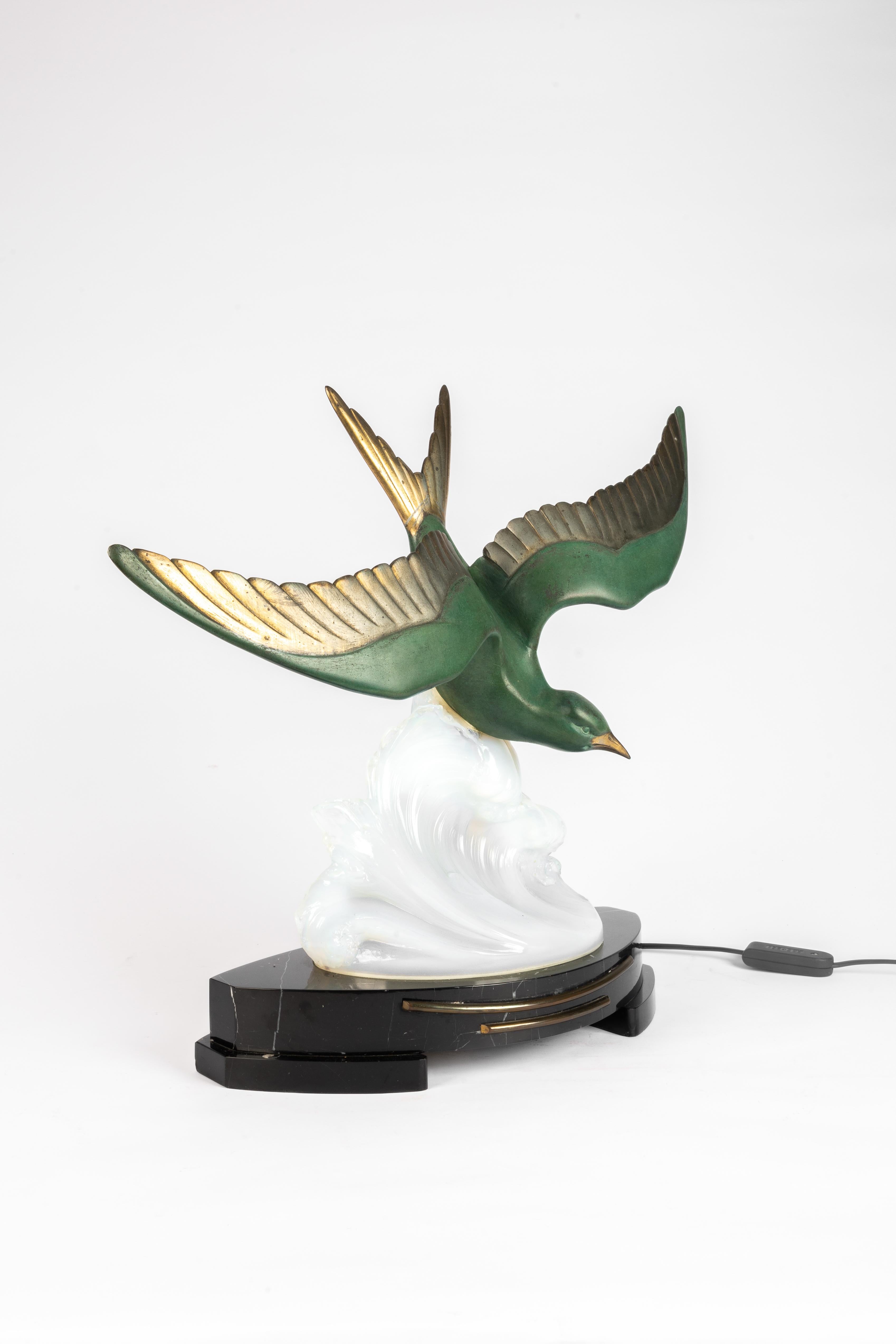 Scultura Art Déco di un gabbiano che atterra in cima a un golfo marino.
Realizzato in spelta e vetro opalino modellato su una base di marmo nero.

Attribuito a Fritz Diller (1875-1946)
Realizzato dall'azienda belga UCRA (con una piccola etichetta