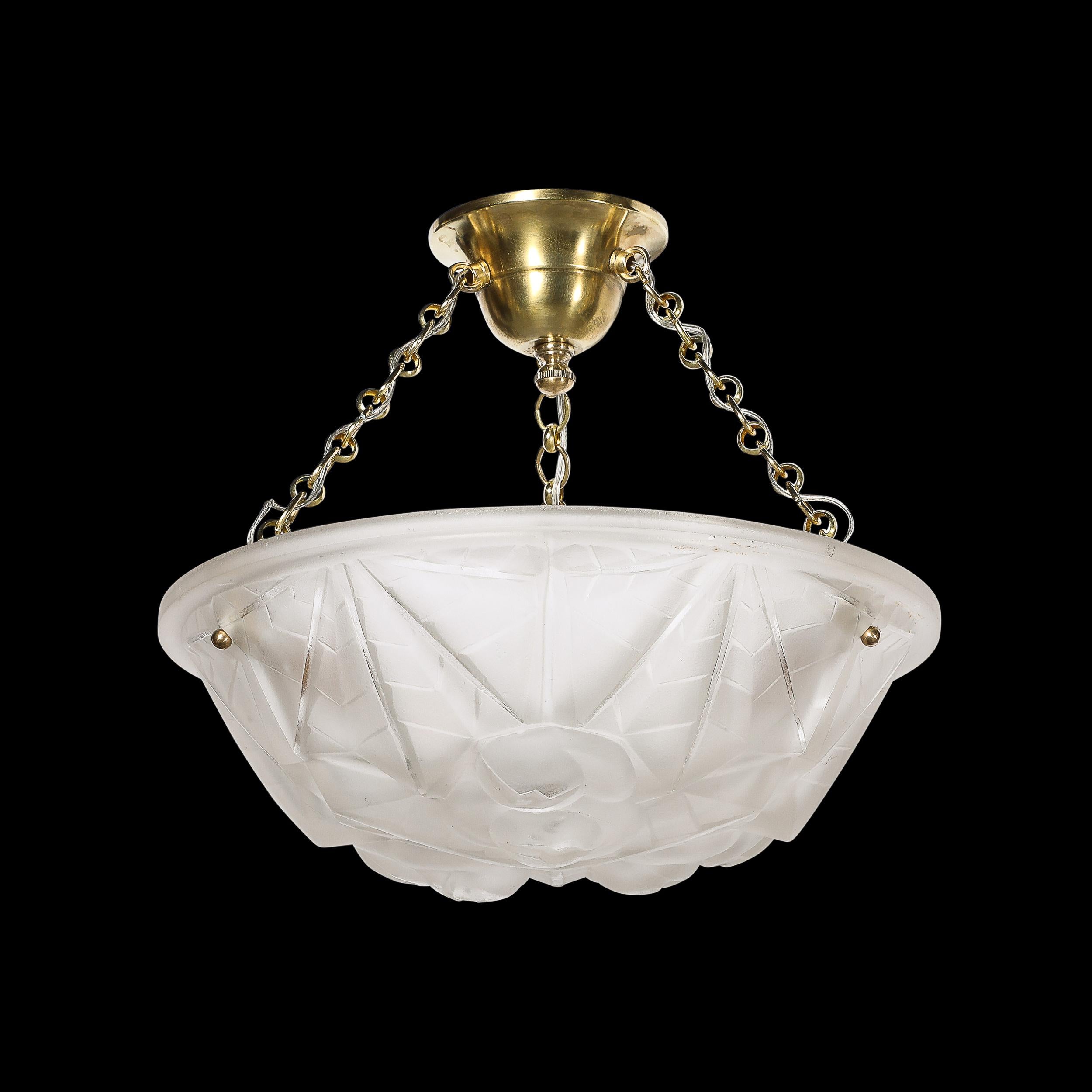 Questo lampadario a sospensione in vetro smerigliato Art Deco, elegantemente geometrico e con finiture in ottone, firmato Degué, proviene dalla Francia, circa dal 1930. Presenta un paralume in vetro smerigliato e modellato con una serie di motivi e