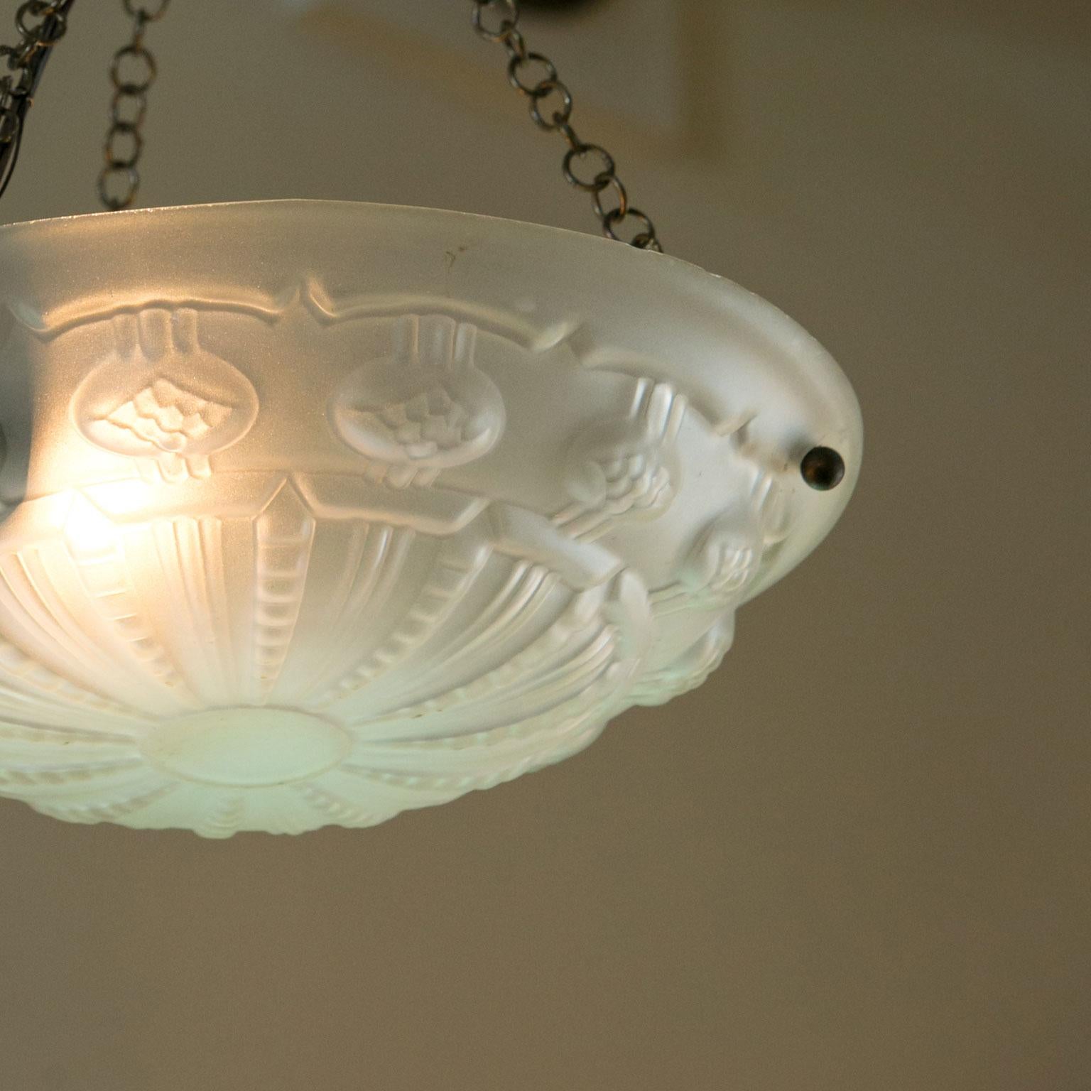 Art Deco frosted glass pendant or chandelier from France. The sweet light has been newly wired for use within the USA. It is all original except for the canopy. It has an interesting geometric motif. The light could have its chain shortened a bit to
