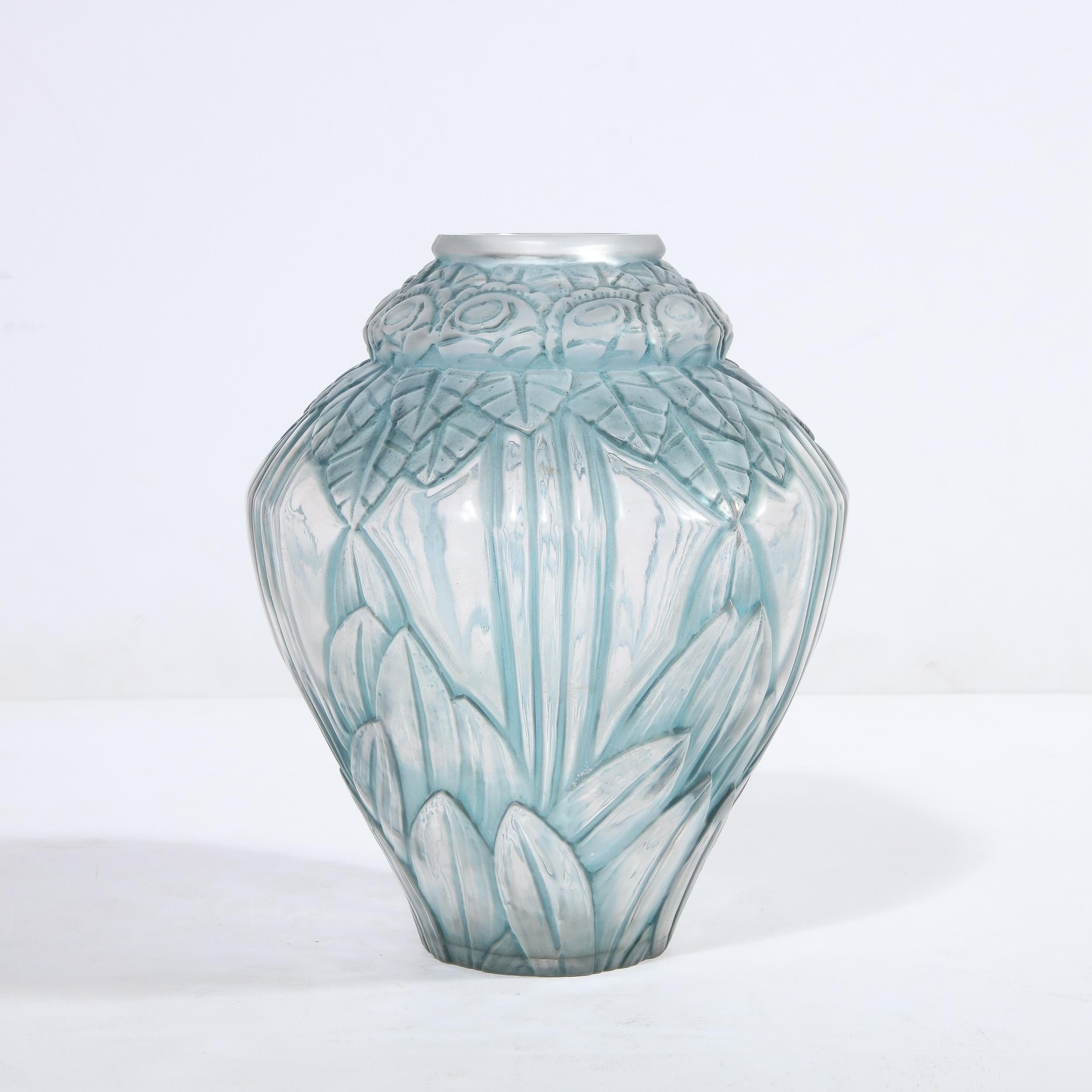 Cet étonnant vase Art Déco en bleu pâle a été réalisé par l'atelier estimé d'Andre Hunebelle (l'un des meilleurs verriers de France à cette époque) vers 1930. Il présente un corps cylindrique robuste qui s'évase au centre et se rétrécit en haut et