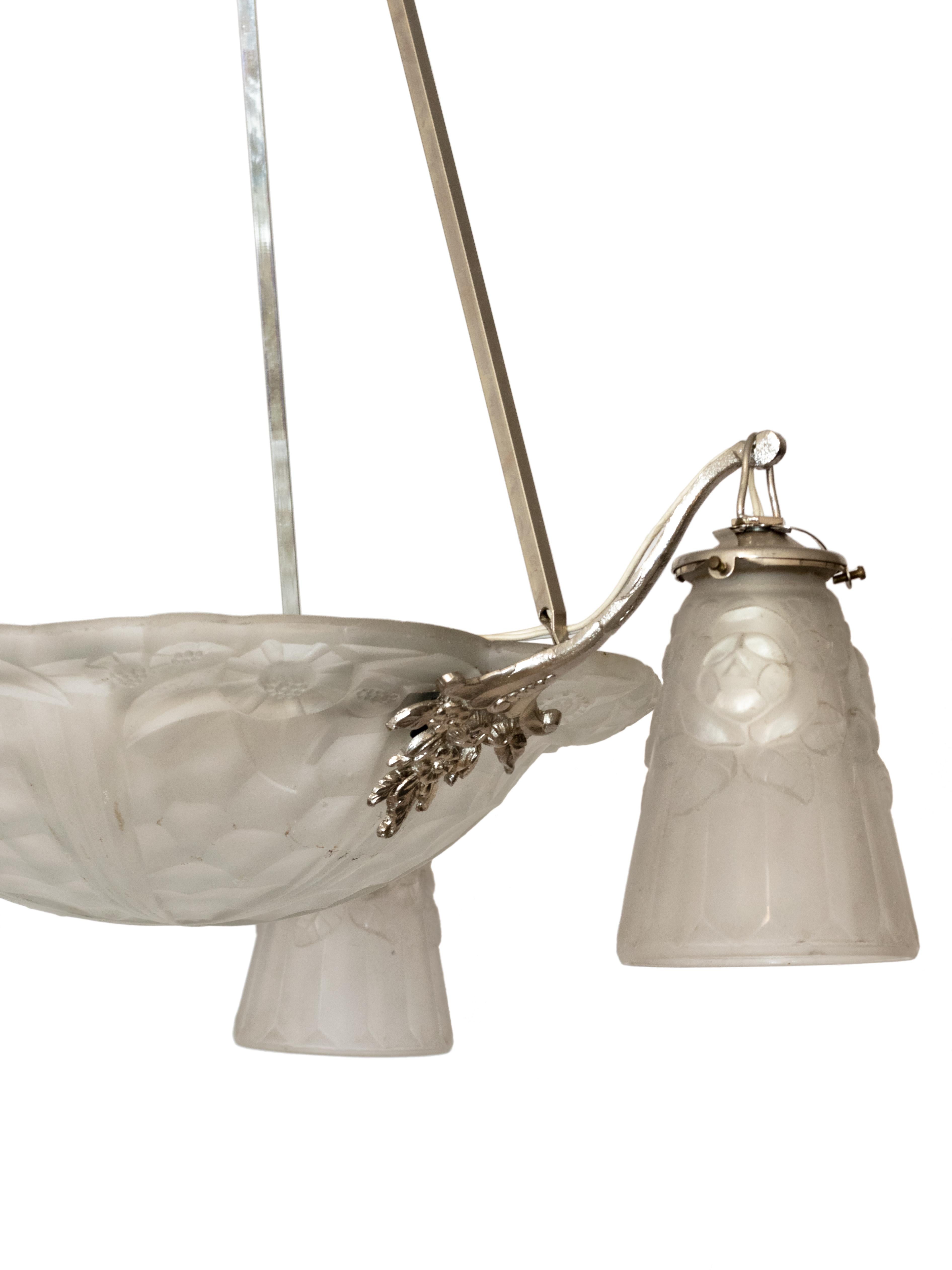 An exquisite white thick frosted glass with an Art Deco stylized floral pattern.
Three “Déngue” signed tulips (mark by David Guéron) and chromed metal structure and lamp.

Height 32,67 in (83 cm) 
Diameter 23,62 in (60 cm)

The chandelier is