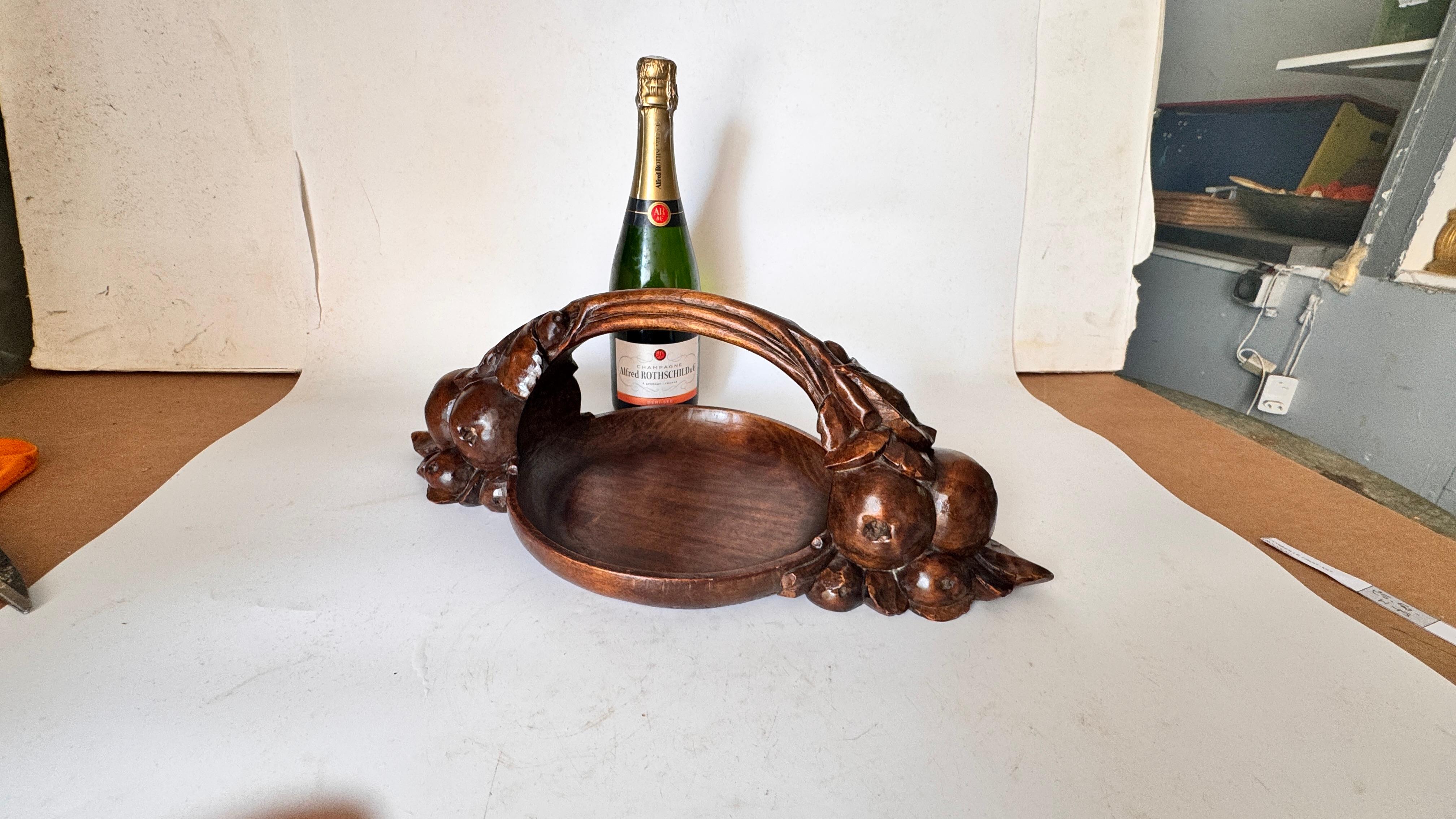 Dies ist ein seltener, handgeschnitzter Art-Déco-Obstkorb aus massivem braunem Holz, der wahrscheinlich in den 1930er Jahren in Frankreich hergestellt wurde. Besonders auffällig ist das Design mit den in den Korpus der Schale integrierten,