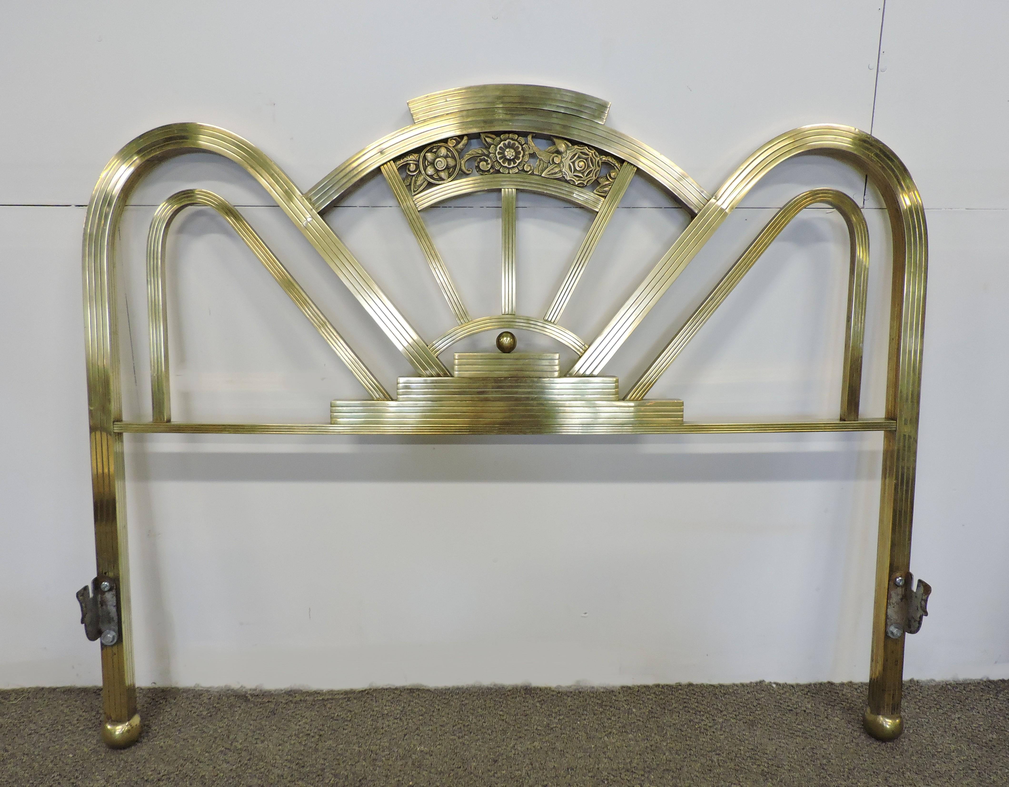 Glamourous and unique Art Deco brass bed from the 1930s. This set includes a headboard and footboard in an arched and stepped design with floral accents and ball feet. At 52.5 inches wide, this could be used with a full size, or possibly a queen