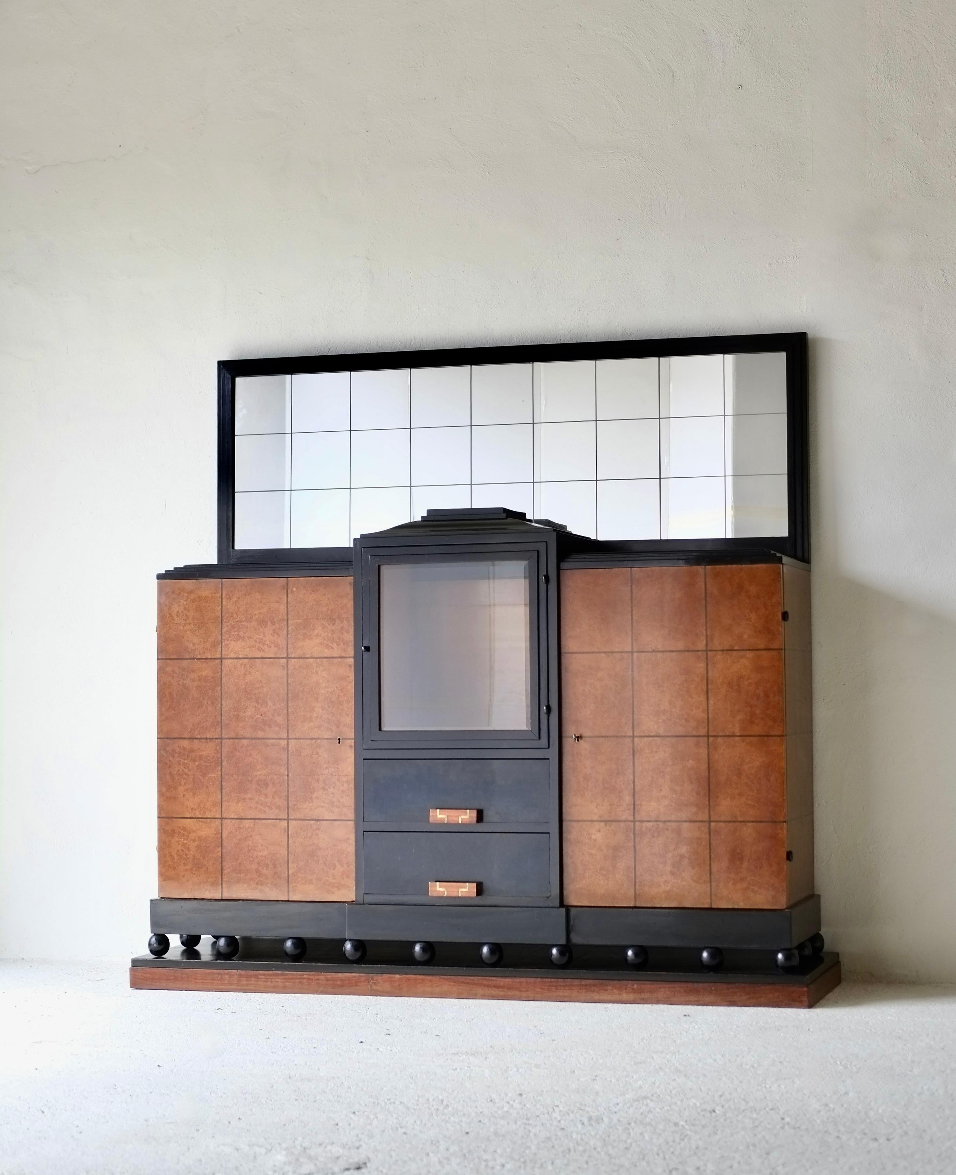 Un eccezionale mobile a specchio Art Deco progettato dal designer italiano Gaetano Borsani per Atelier di Varedo.

Art Deco italiana con influenza neoclassica.

C1925, Italia.

Mobile centrale con un'anta in vetro sopra due cassetti con maniglie in