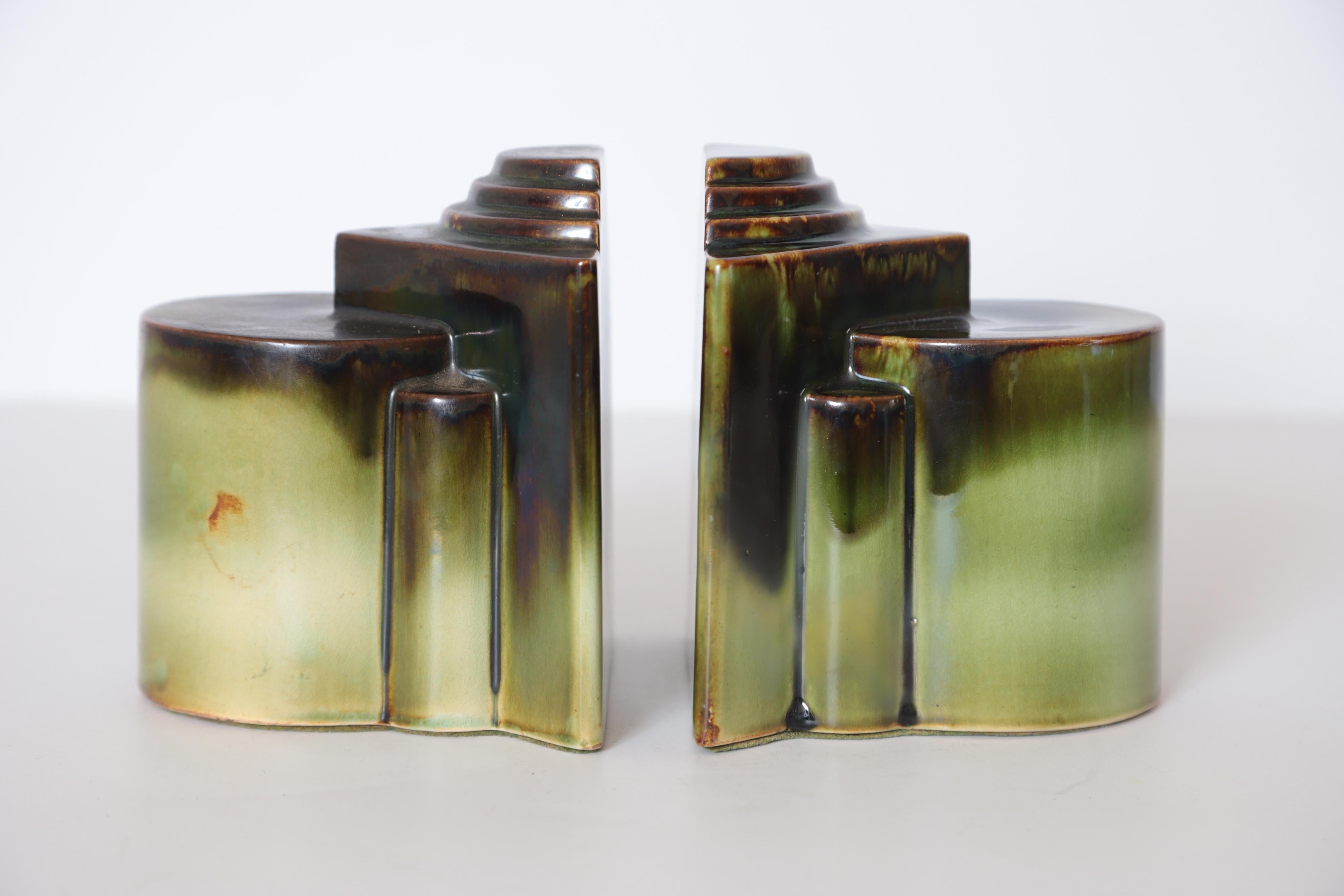 Important Art Deco Gale Turnbull for Leigh Potters bookends, circa 1929, Leigh art ware

Uncommon example of the early American streamline skyscraper cubist architectural design motif.
Very nice multi-hued green drip with brown edge