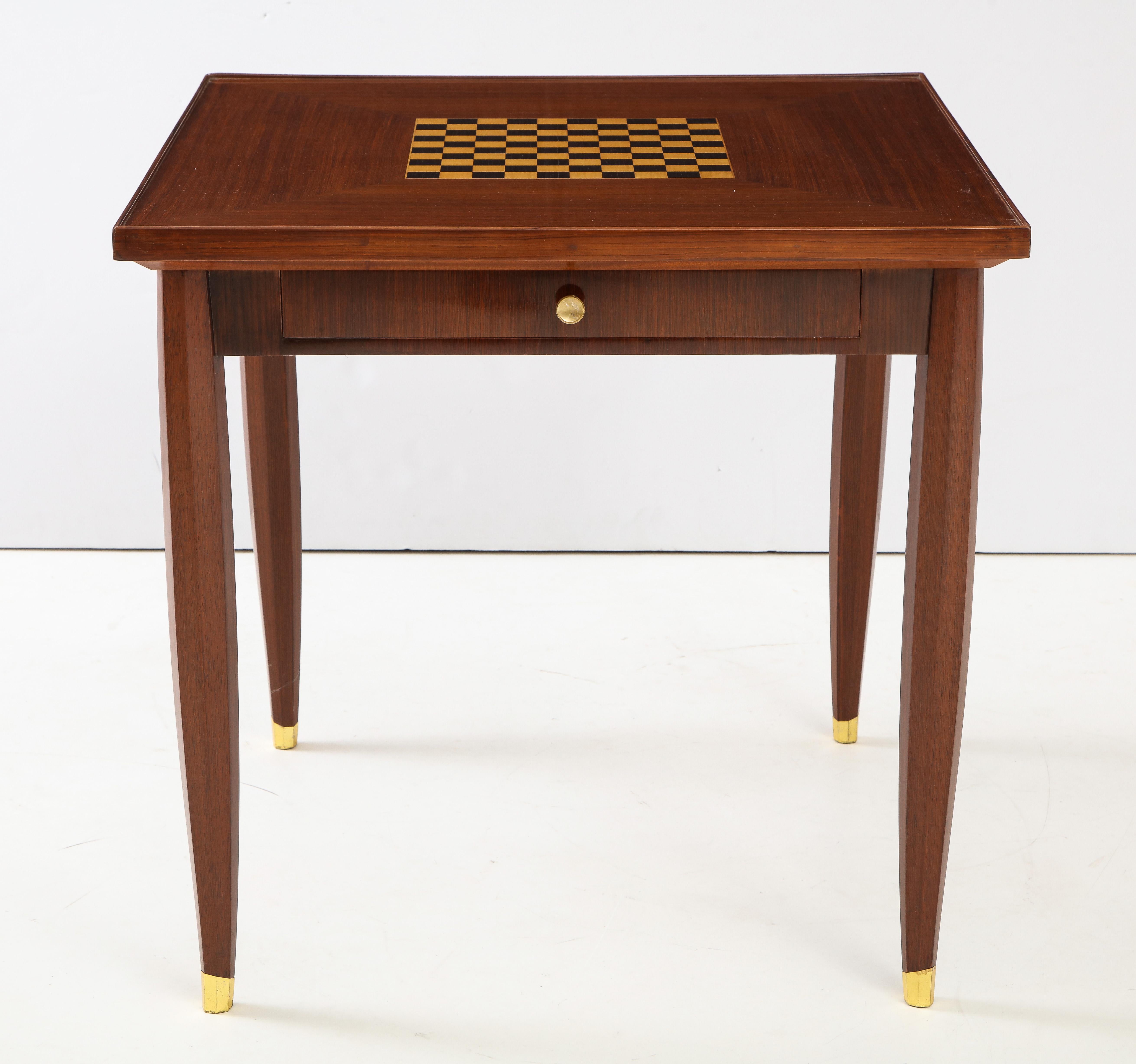 The mahogany top, with an inlaid sycamore and ebony chess board, having an apron with 2 drawers supported by molded legs with gilded feet.
  