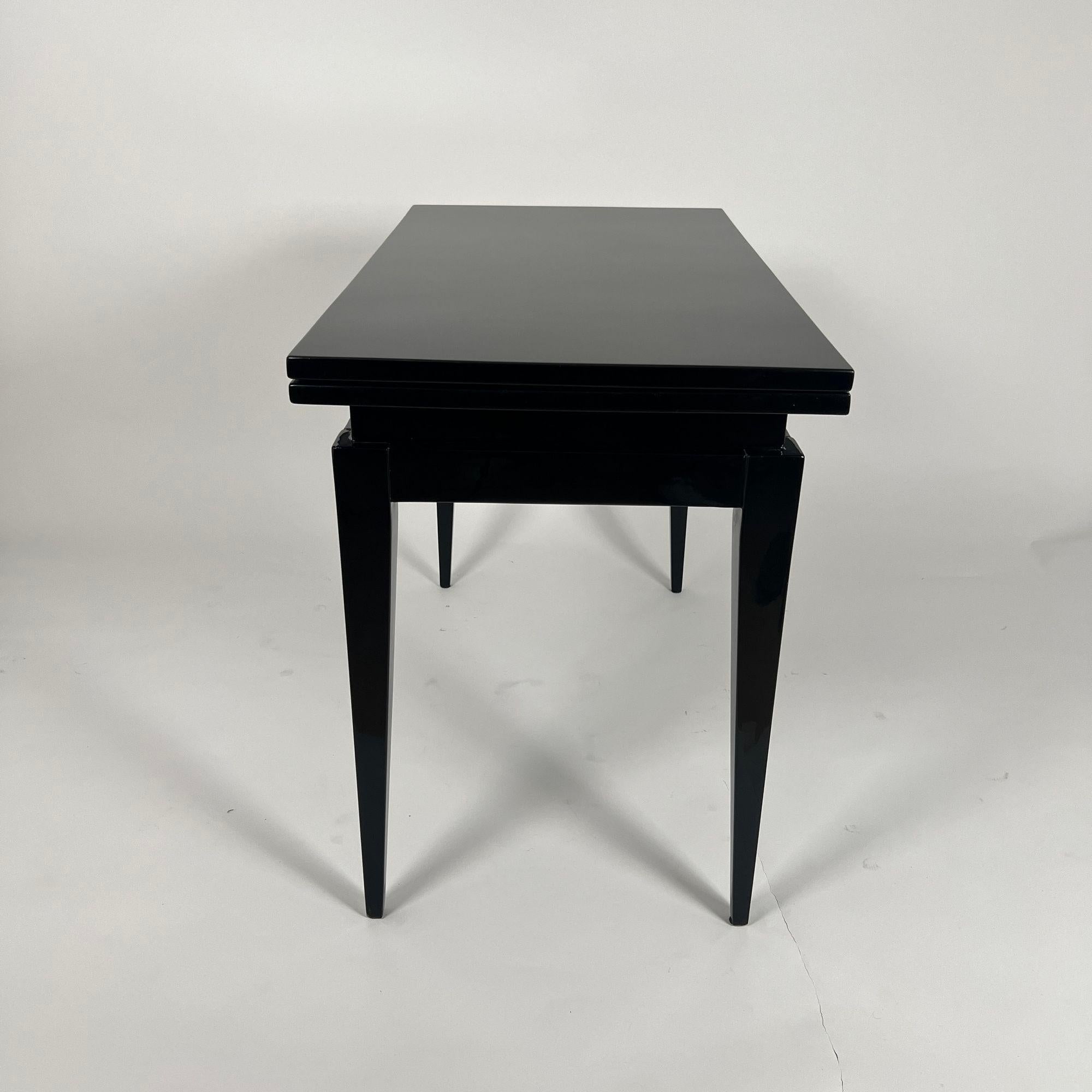 Umwandelbarer originaler Art Deco Spieltisch aus Frankreich um 1930.
Oberfläche aus schwarzem Klavierlack, hochglanzpoliert.
Die obere Platte kann gedreht und gefaltet werden, um die Platte zu vergrößern. Im ausgeklappten Zustand dient eine schwarze