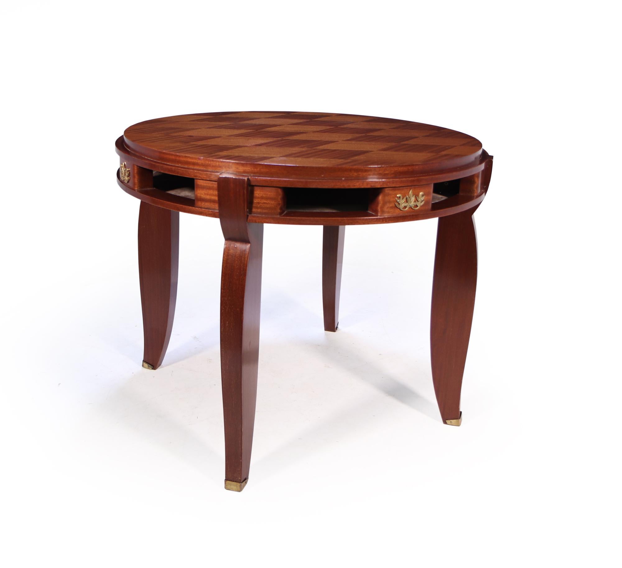 Ein Mahagoni-Parkett-Tisch, der von Jules Leleu in den 1940er Jahren in Frankreich hergestellt wurde. Er hat vier säbelförmige Beine mit Säbeln am Fuß, die Platte hat acht Fächer und vier florale Plaketten. Der Tisch ist in einem ausgezeichneten