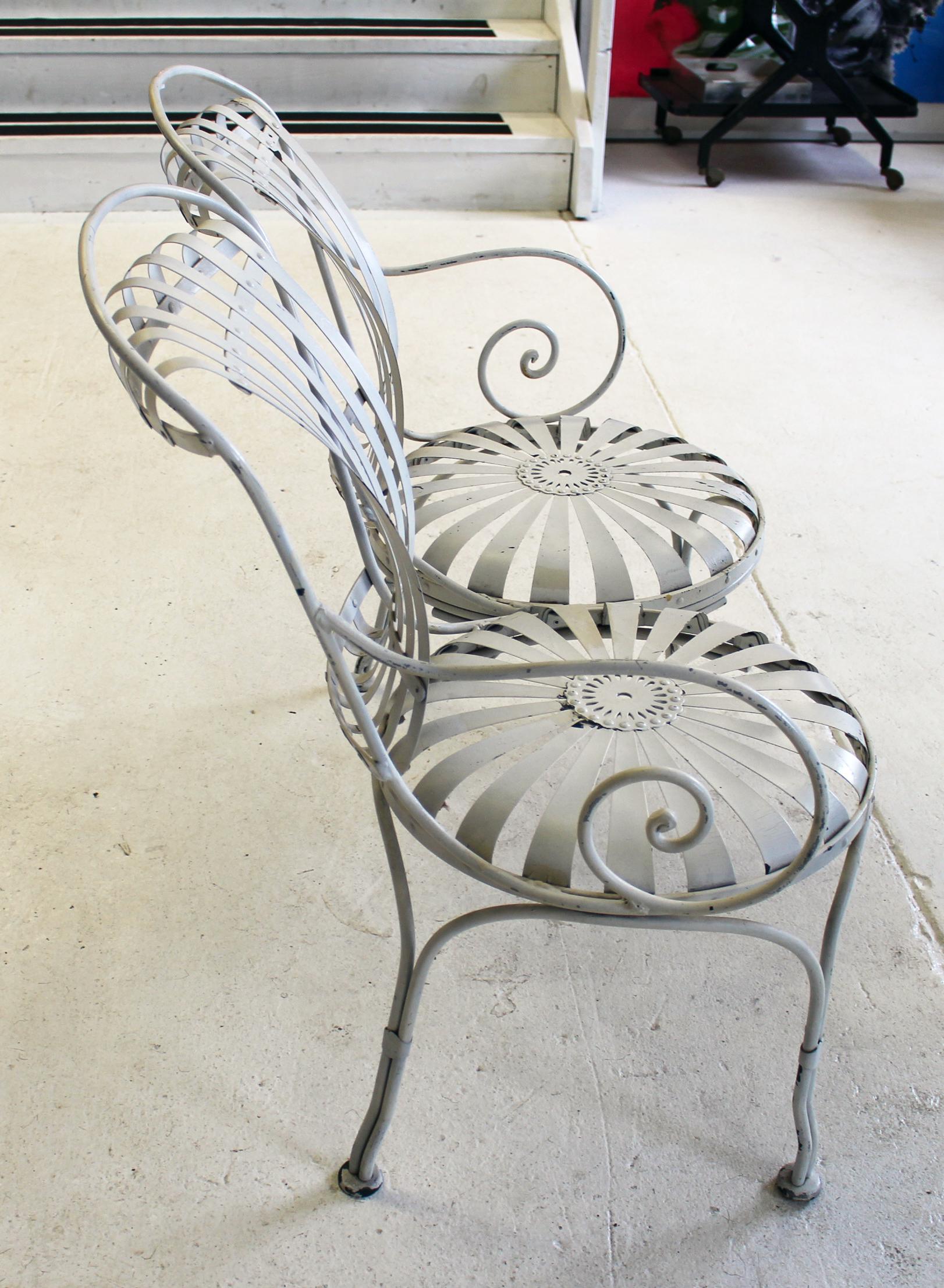 Stylized after Francois Carre with sunburst seats, vertical concave steel slat backs and wrought iron legs and curled arms.