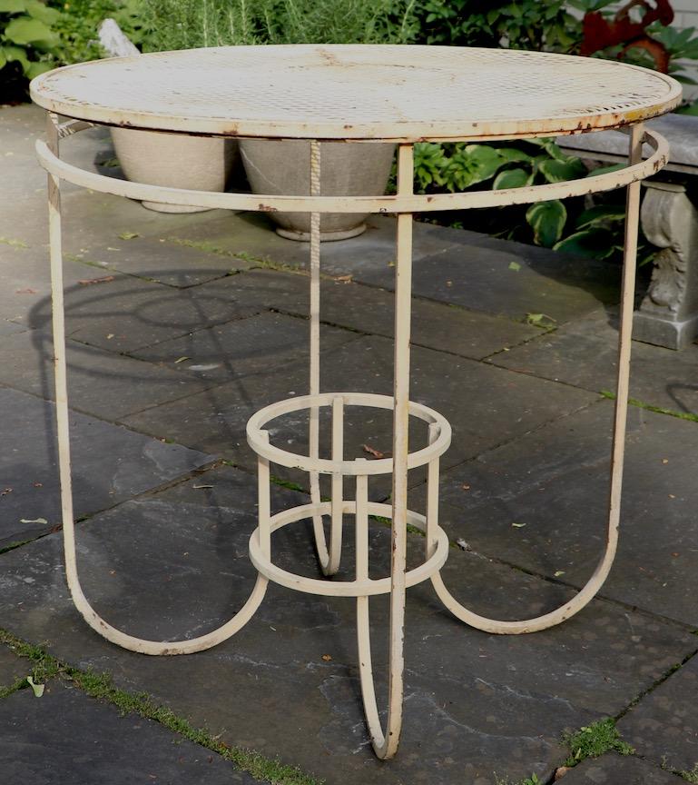 Very stylish center table made by Woodard Furniture Company. Unusual and nit often seen form, originally designed as a center table, but also suitable for use as a cafe or side table as well. Currently in later French Vanilla paint finish, which