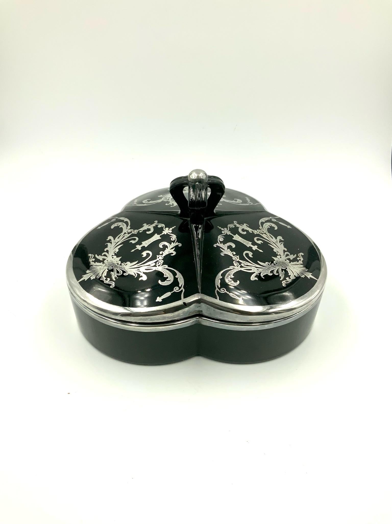 Simply elegant early 20th century silver overlay black glass covered divided candy dish / jar / box featuring three sections with a foliate, cartouches and scroll silver overlay design. The lid finial looks similar to a crown. There are silver rims