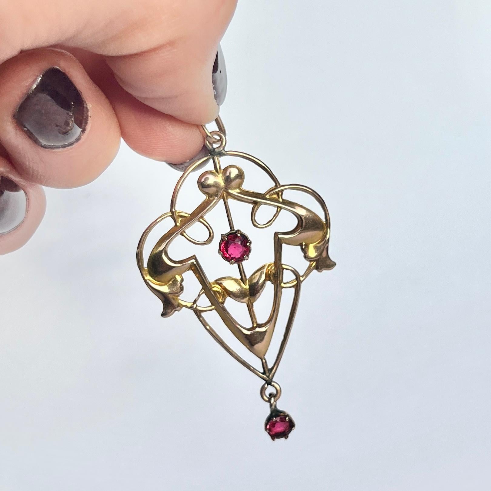 This sweet pendant holds 2 garnet stones and surrounding it is the most ornate gold work. central garnet diameter 5mm. Modelled in 9ct gold.

Drop from loop: 55mm
Pendant Diameter: 30mm

Weight: 1.9g