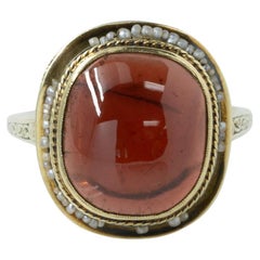 Anillo Art Decó de oro amarillo con cabujón de granate y semilla de perla