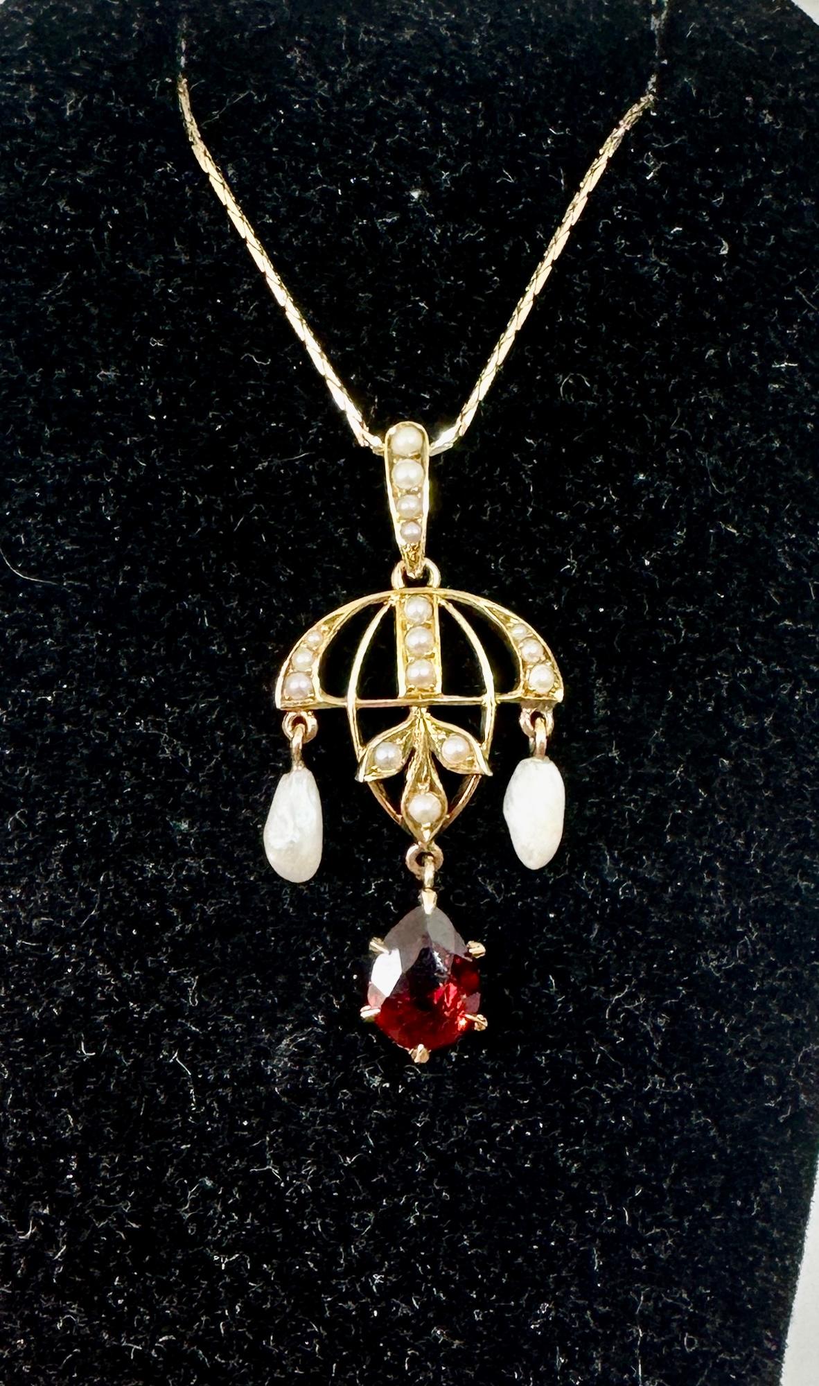 This is a beautiful Victorian - Art Deco Garnet Pearl Lavaliere Pendant Necklace in 14 Karat Gold in a Chandelier motif.   The lovely and delicate pendant is set with a beautiful pear shape faceted Garnet of a wonderful color.   The pendant is in a
