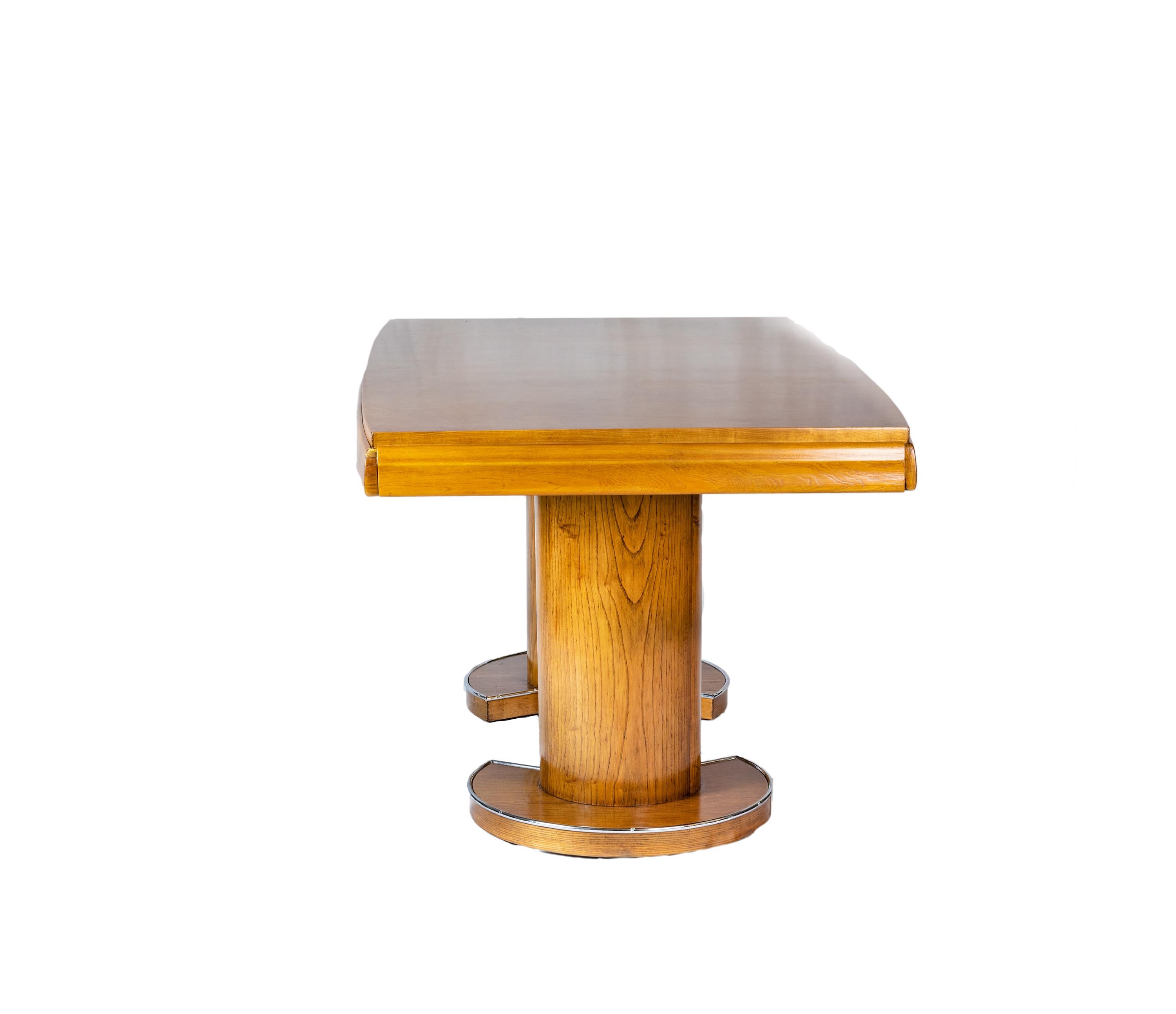 An elegant Art Deco dining table crafted from walnut with a clear finishing of clear veneer with two extensions and chrome iron details on the round base feet.
Gaston Poisson Style table.

With extensions:  Width 92,51 in (235 cm)
Without