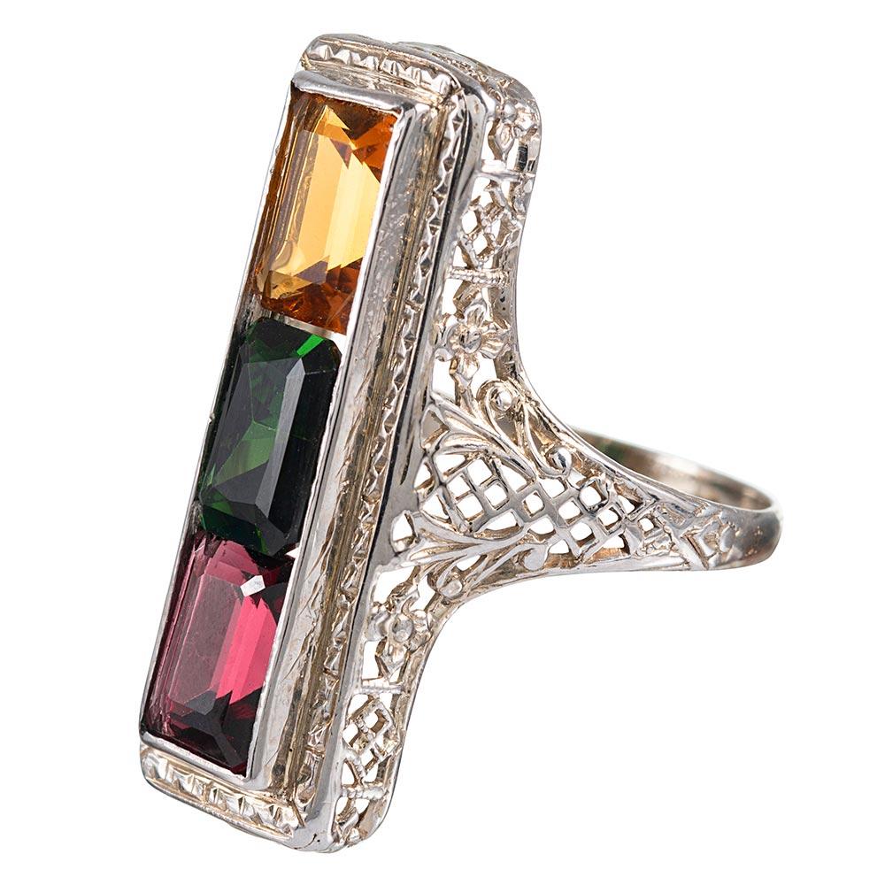 Citrine, green tourmaline and garnet are married within a 14 karat frame of white gold filigree. Charming and colorful, this cheerful ring will bring a smile to your face and is certain to encourage compliments. Size 4.5 can be resized on request.