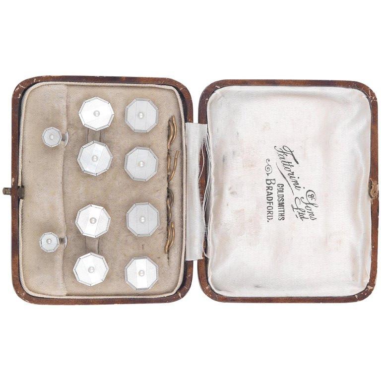
The octagonal mother of pearl panels set with half pearl, stamped 9ct, composed of a pair of cufflinks, four buttons and two collar studs, cased