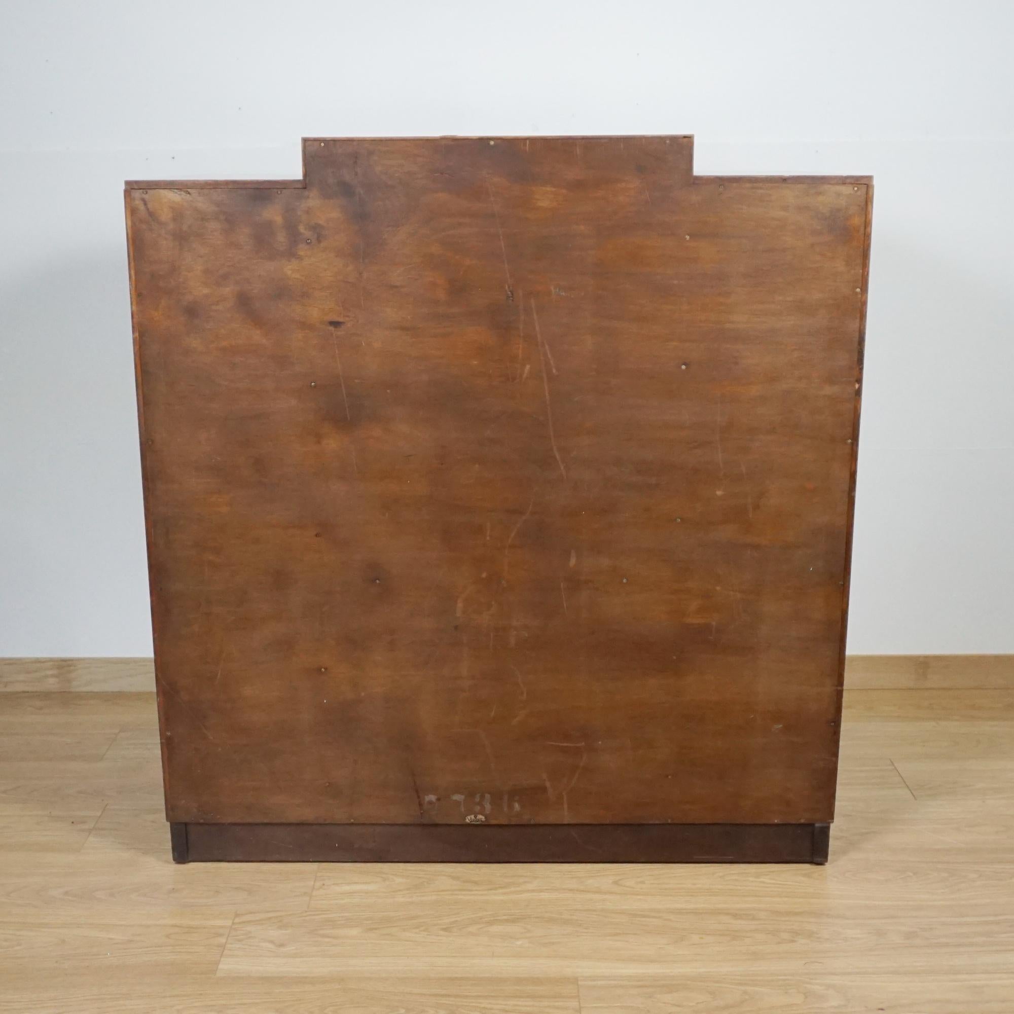 An Art Deco Gentleman's wardrobe. Burr walnut veneered central section comprising of two lower drawers and an upper interior shelved section, flanked by two figured walnut wardrobed sections to either side. Macassar ebony banding throughout with