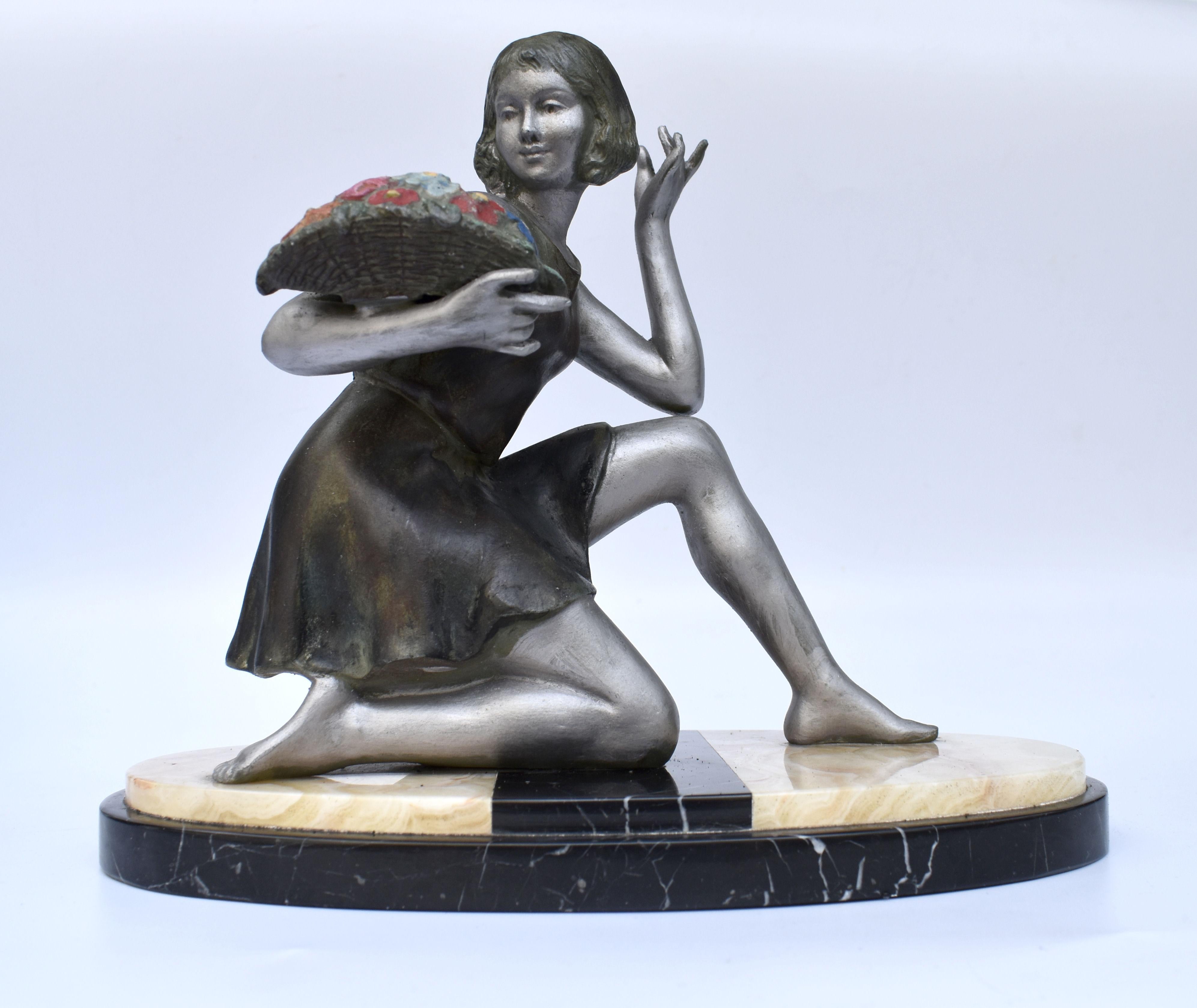 - Figura femminile in stile Art Deco Geo Maxim
Deliziosa figura francese Art Déco degli anni '30 raffigurante una ragazza che tiene un cesto di fiori in policromia. La base è in marmo massiccio altamente lucidato. Firmato Geo Maxim. Il pezzo è in